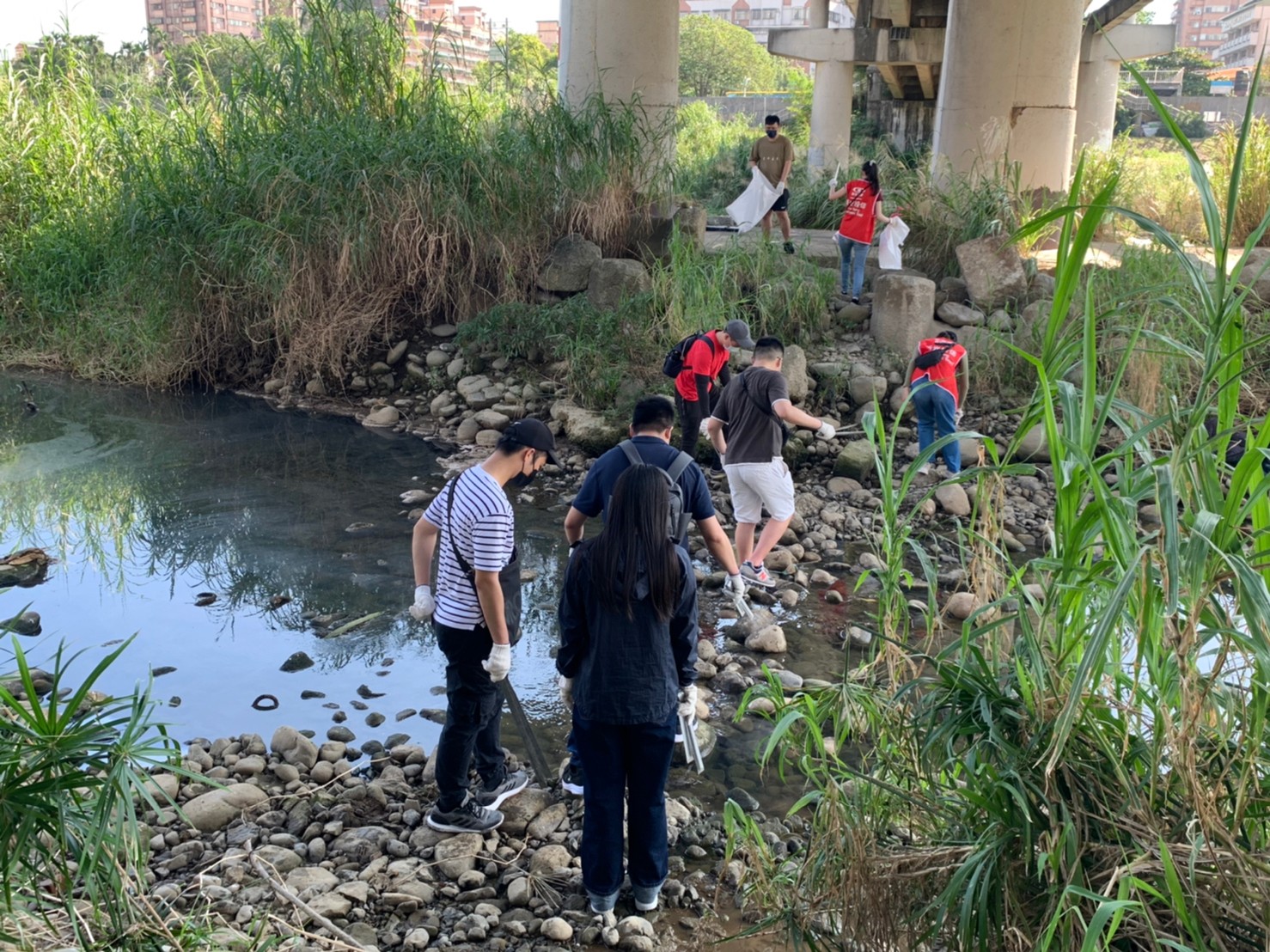 新光投信企業志工涉水過溪  撿拾掉落在溪中的垃圾