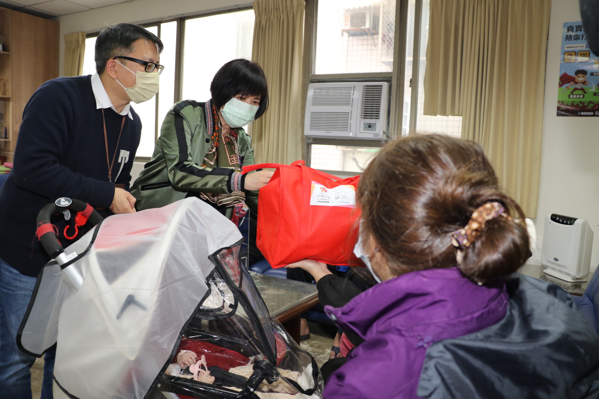 台灣好樣協會理事長張方寧（中）和社會局主任秘書黃逢明一起將年菜送給家戶