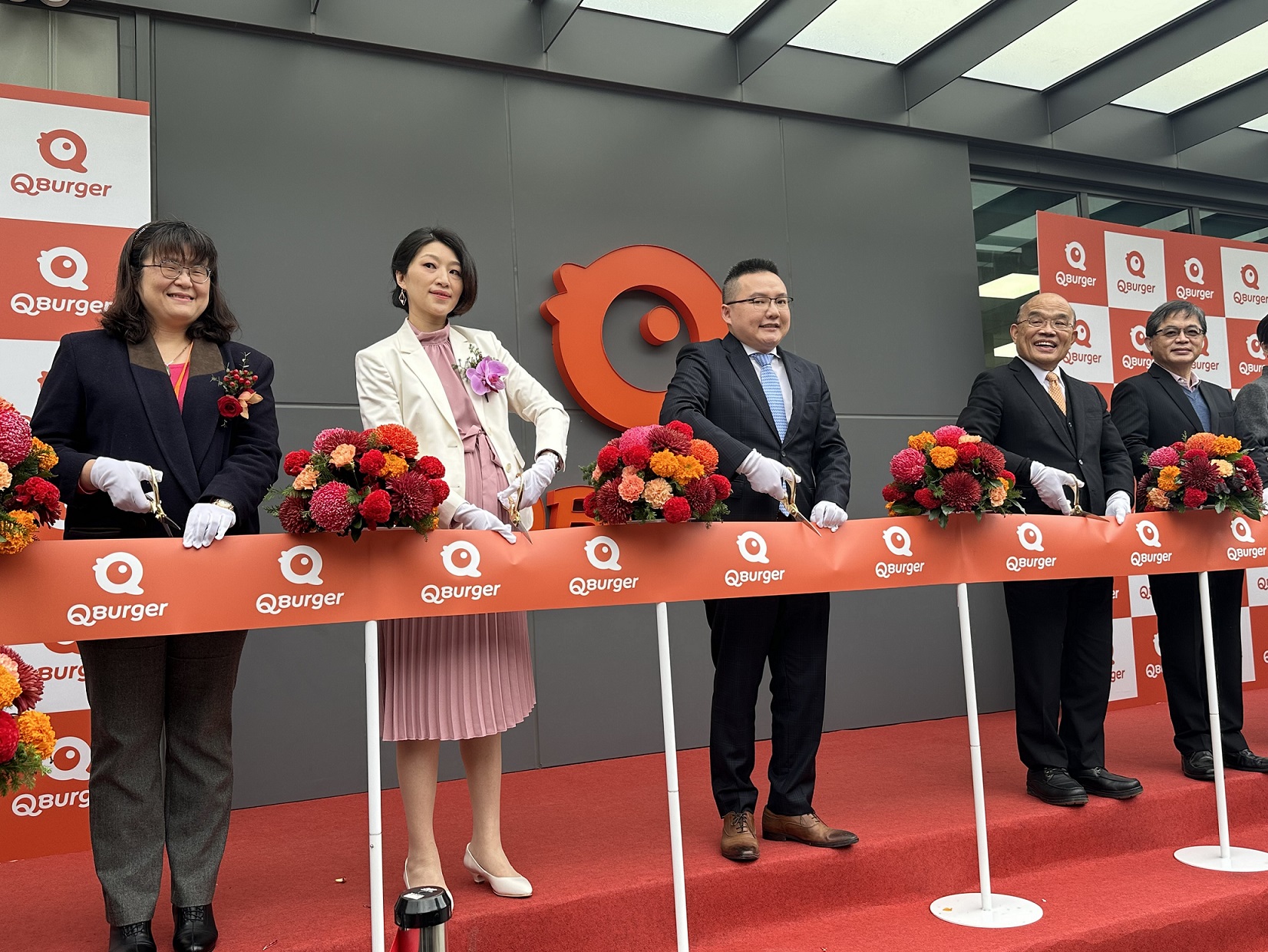 行政院蘇貞昌院長、新北市政府經發局長何怡明、饗樂餐飲(Q Burger)董事長鄭瑞賓等貴賓共同剪綵，恭賀營運總部成立