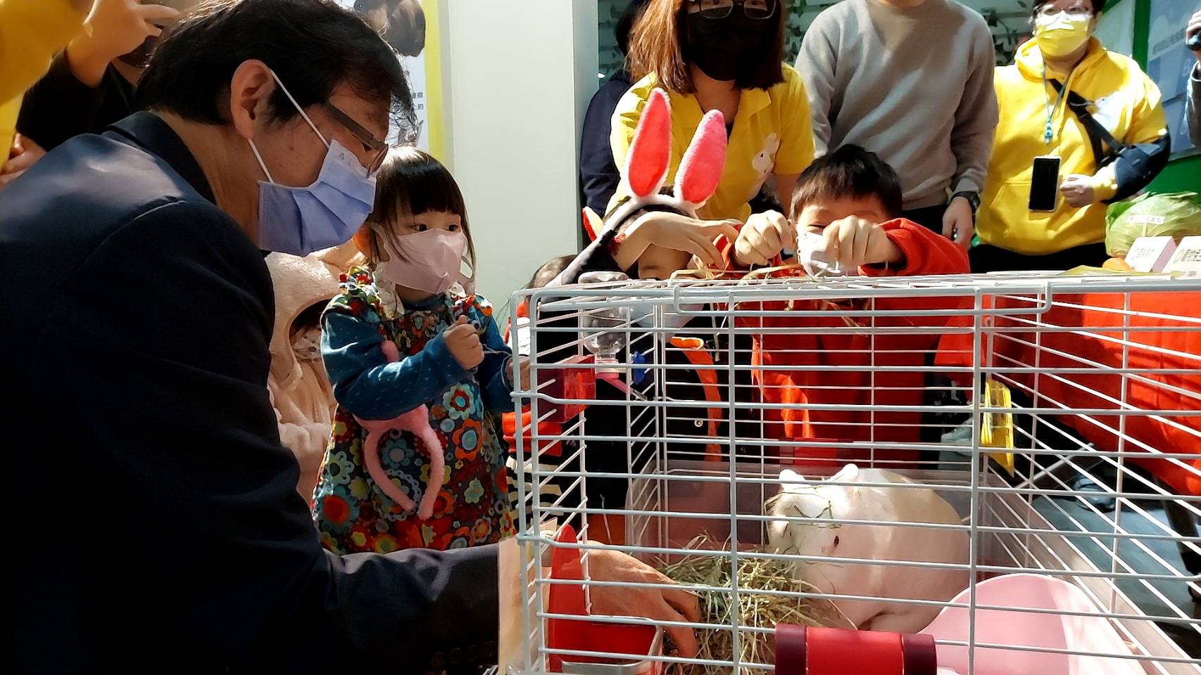 新北市農業局副局長諶錫輝與現場小朋友一同餵兔子吃牧草