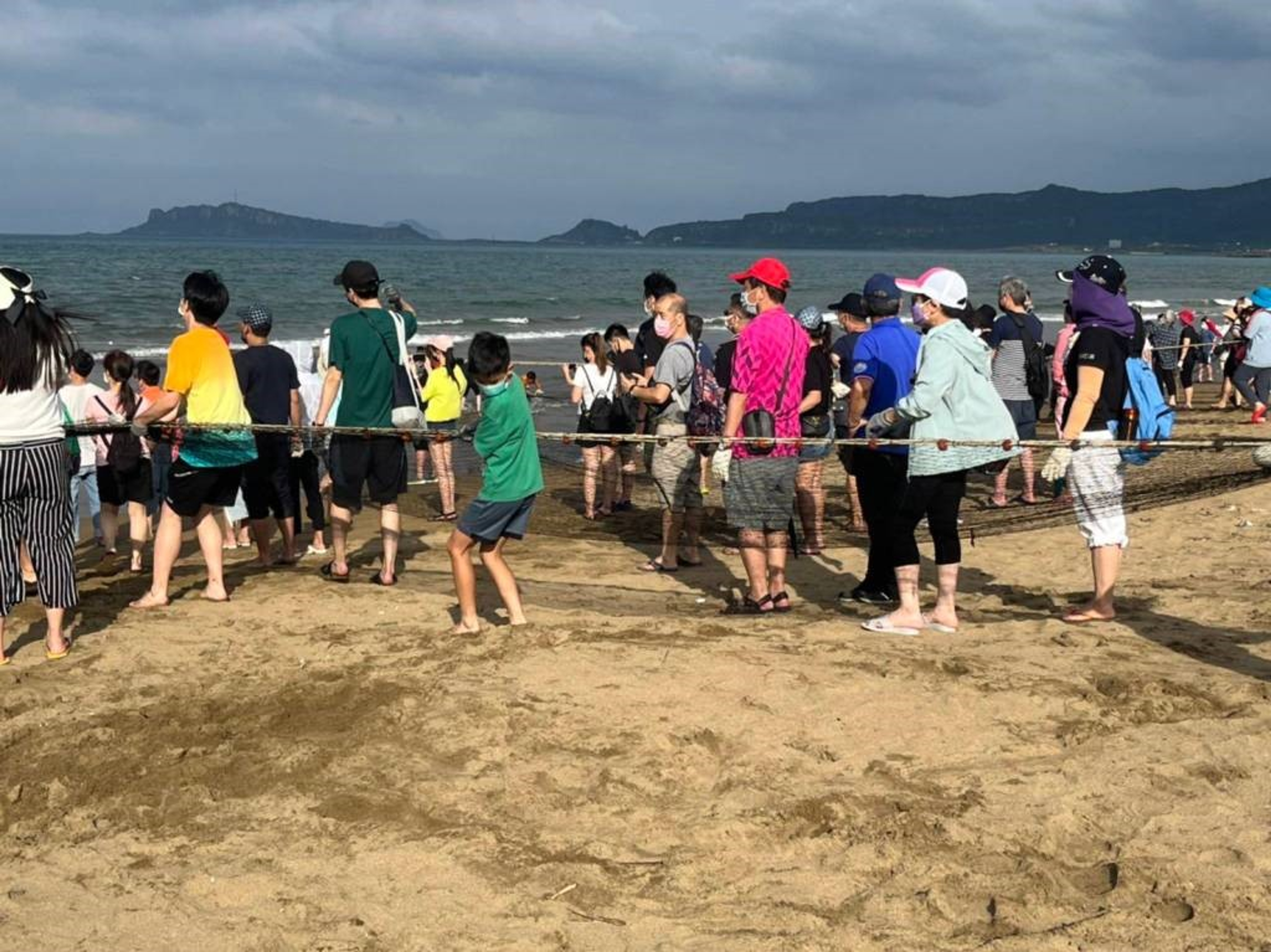 民眾體驗「牽罟」活動，齊心協力將罟網往岸上拉。