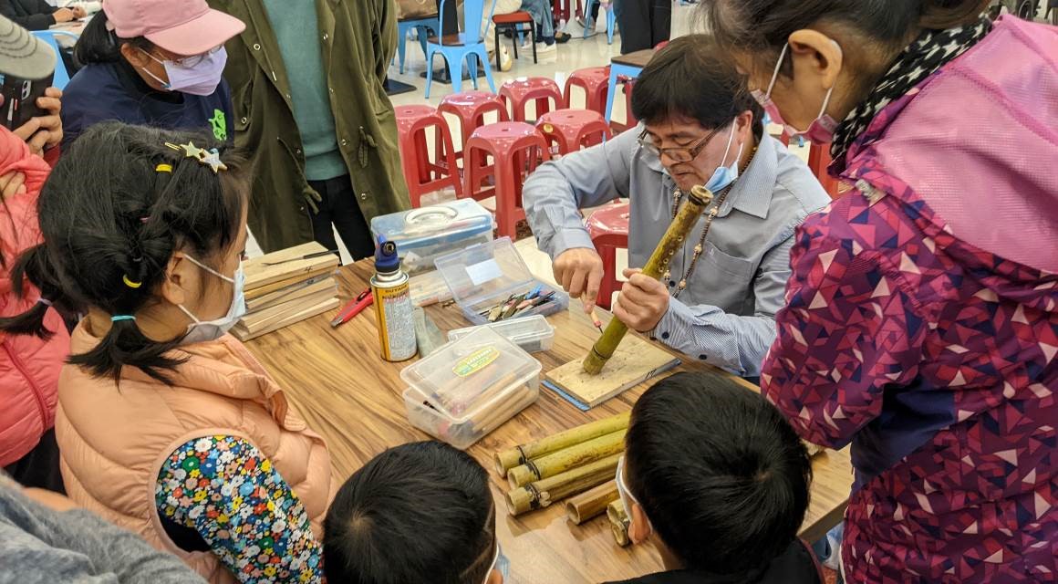 原住民族傳統技藝相當精采，圖為汐止成果展中謝金水老師現場教導民眾製作太魯閣族傳統獵笛。(圖/新北市政府原民局提供)