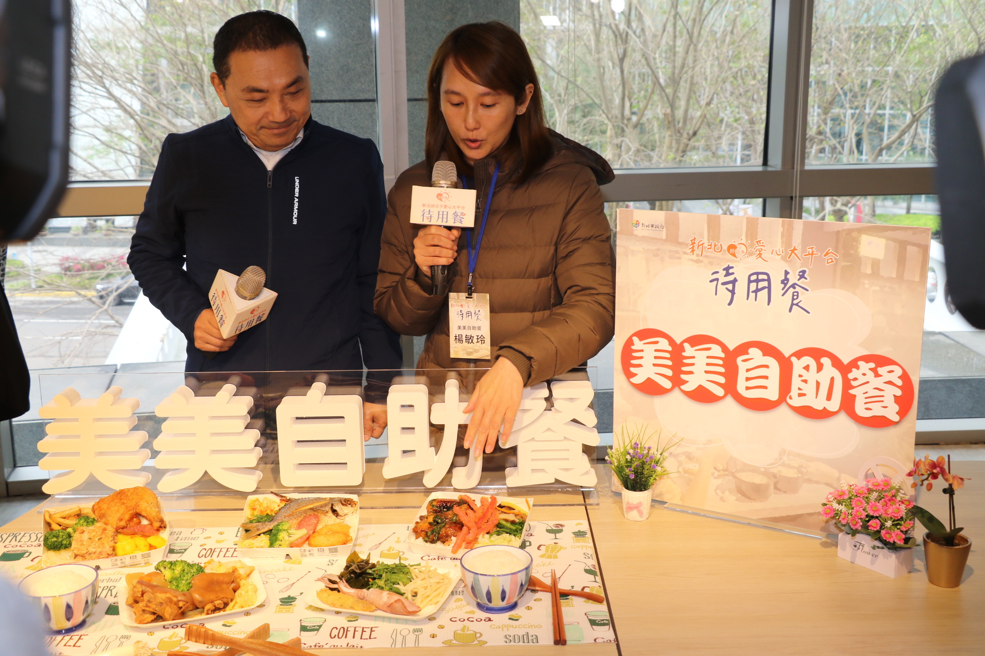 美美自助餐老闆楊敏玲為侯友宜介紹所提供的待用餐內容包含魚、肉等