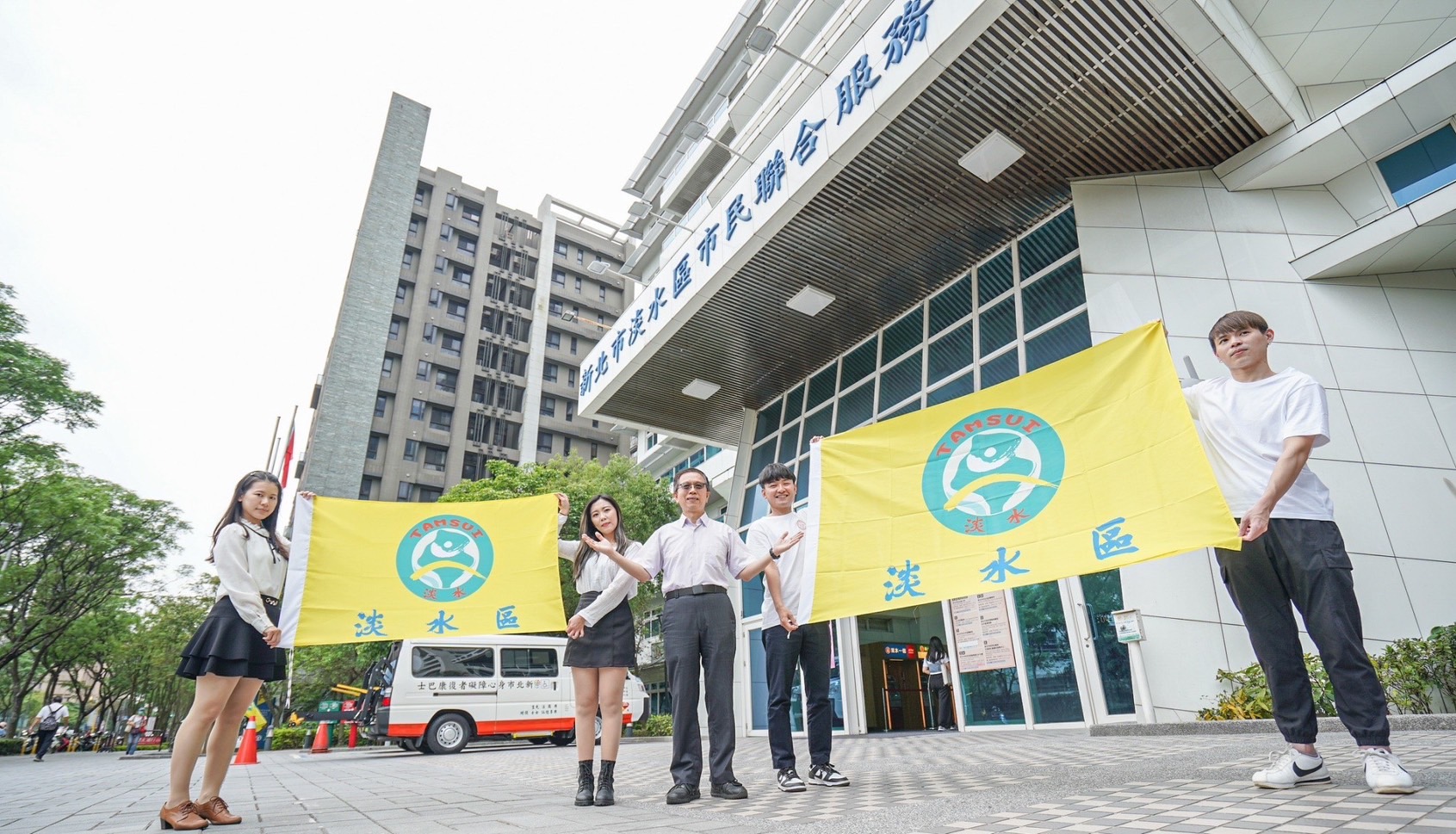 以淡水行政區輪廓為背景，跳躍的人形意象代表著淡水的活力
