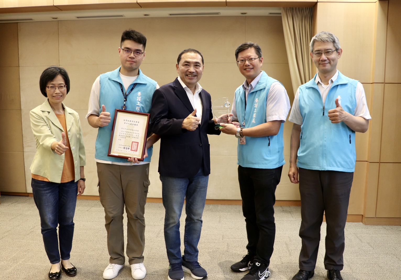 :新北市政府養工處以路燈資訊管理榮獲2023年第十九屆金圖獎「應用系統獎」，今日市政會議由工務局長祝惠美(左1)及養工處長簡必琦(右1)率領團隊成員，將此殊榮獻給新北市長侯友宜(中)。