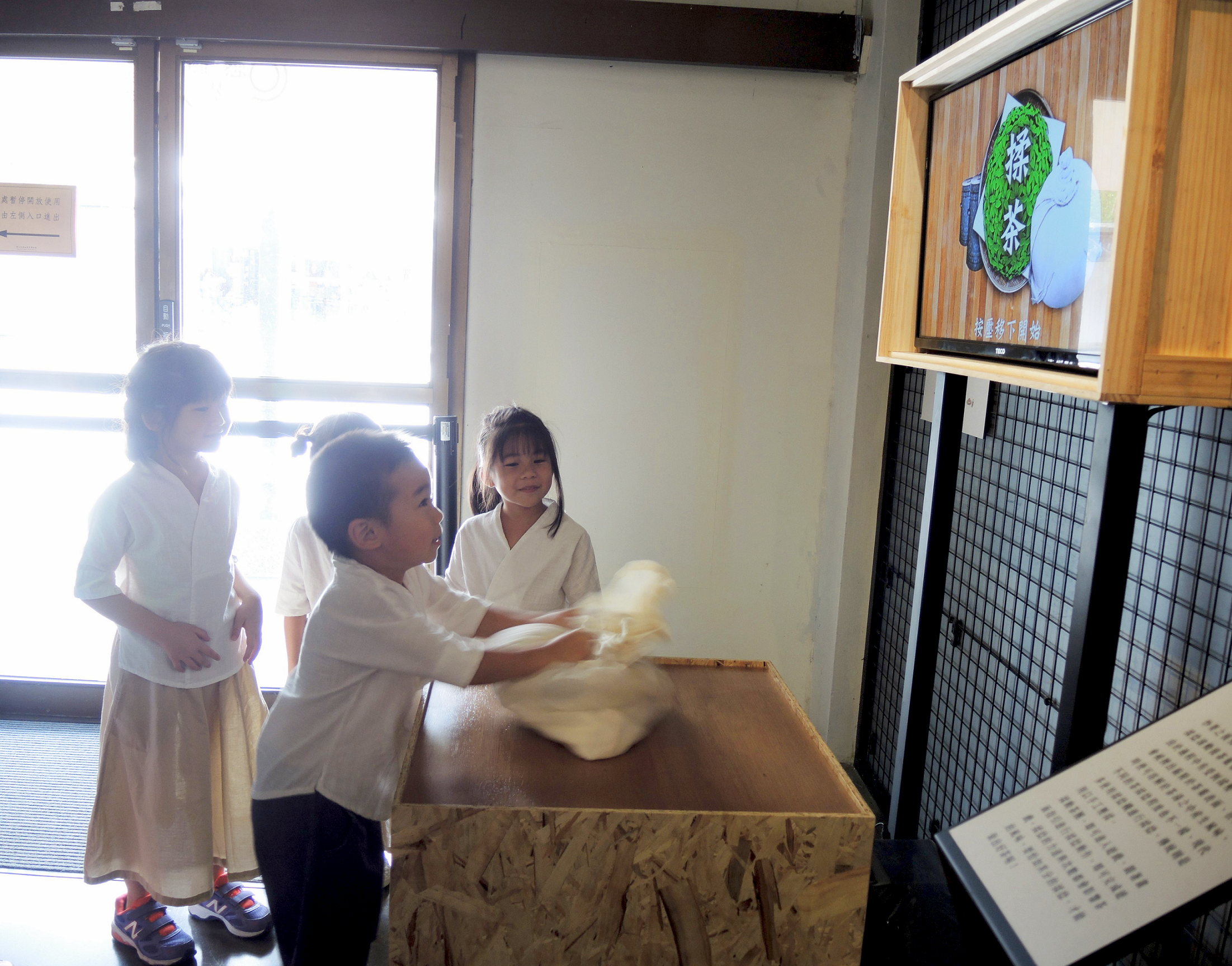 小朋友在新北市坪林茶業博物館「曉茶塾」展覽中透過數位科技體驗揉茶過程