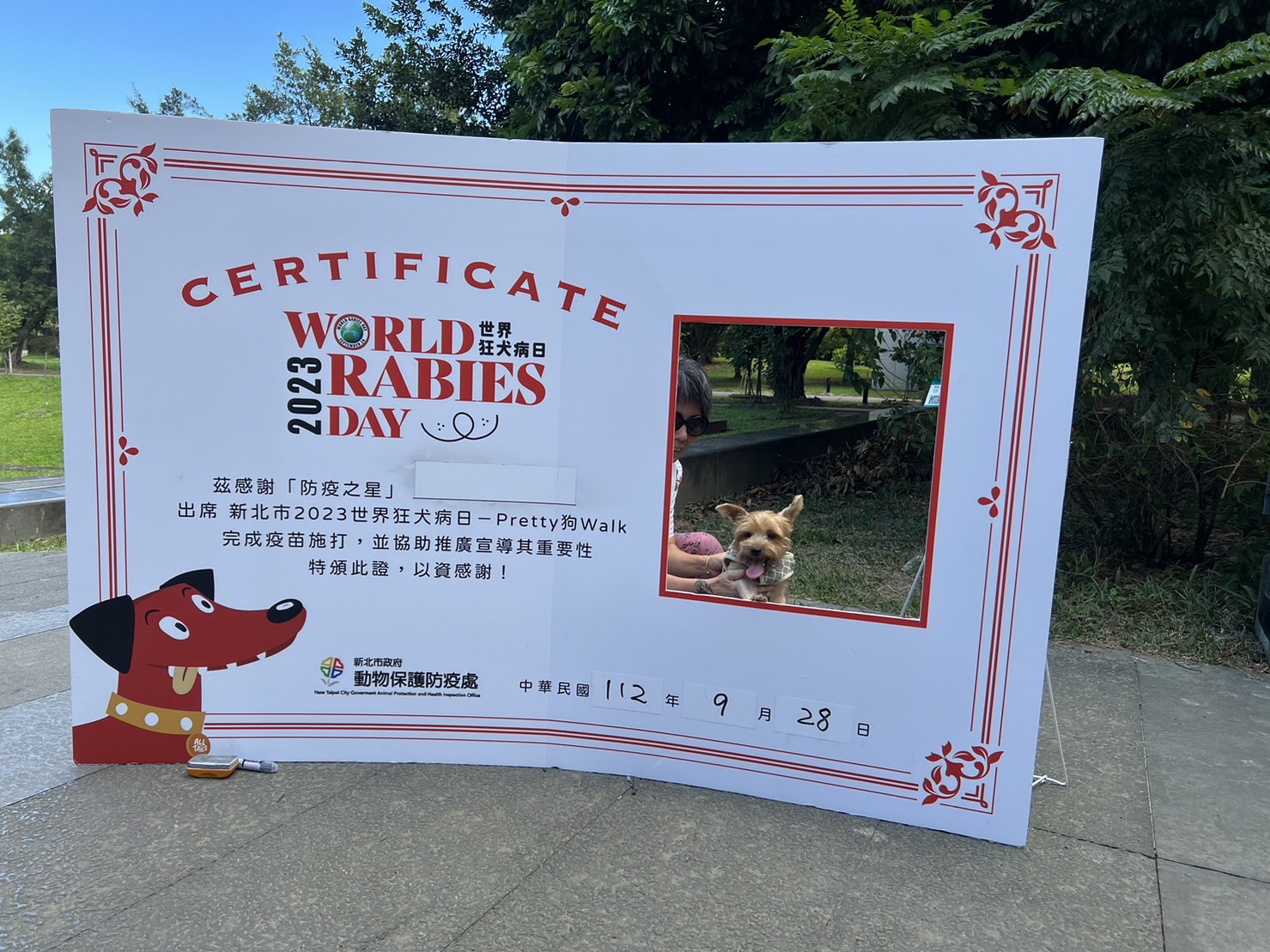 民眾帶著狗狗和世界狂犬病日主題拍照框拍照