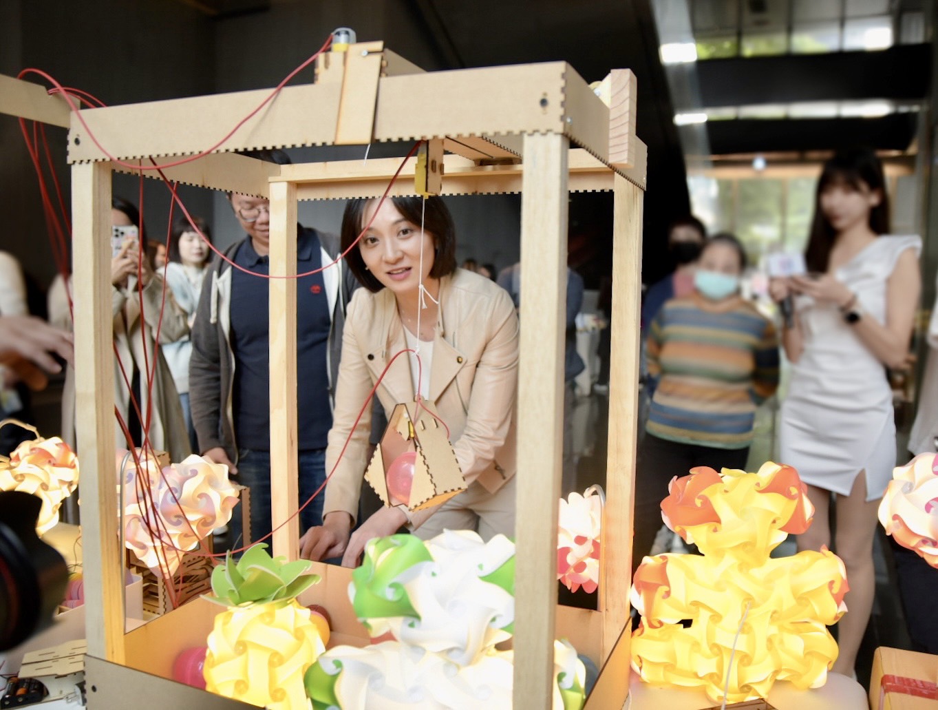 新北青創五股自造基地年度成果展，青年局長邱兆梅體驗「蔡昱騰老師工作室」研發的創客遊具。