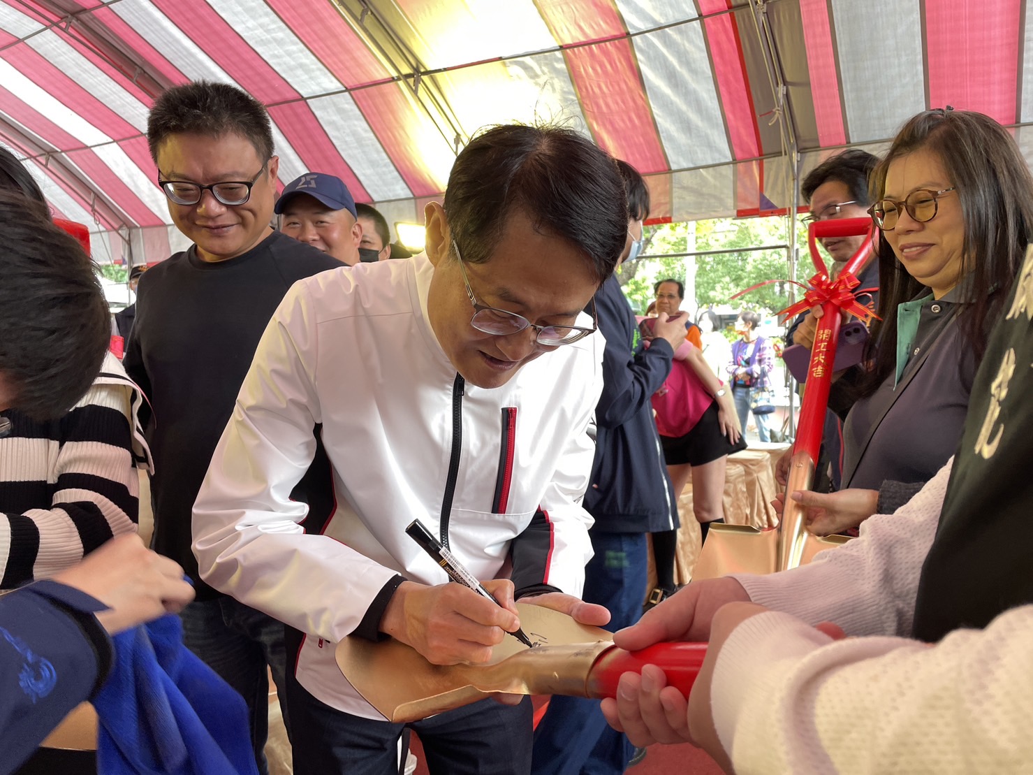 當地里長及居民們，熱情邀請陳純敬副市長在金鏟上簽名，預祝玫瑰立體停車場工程圓滿順利，帶給三重居民更優質的生活環境