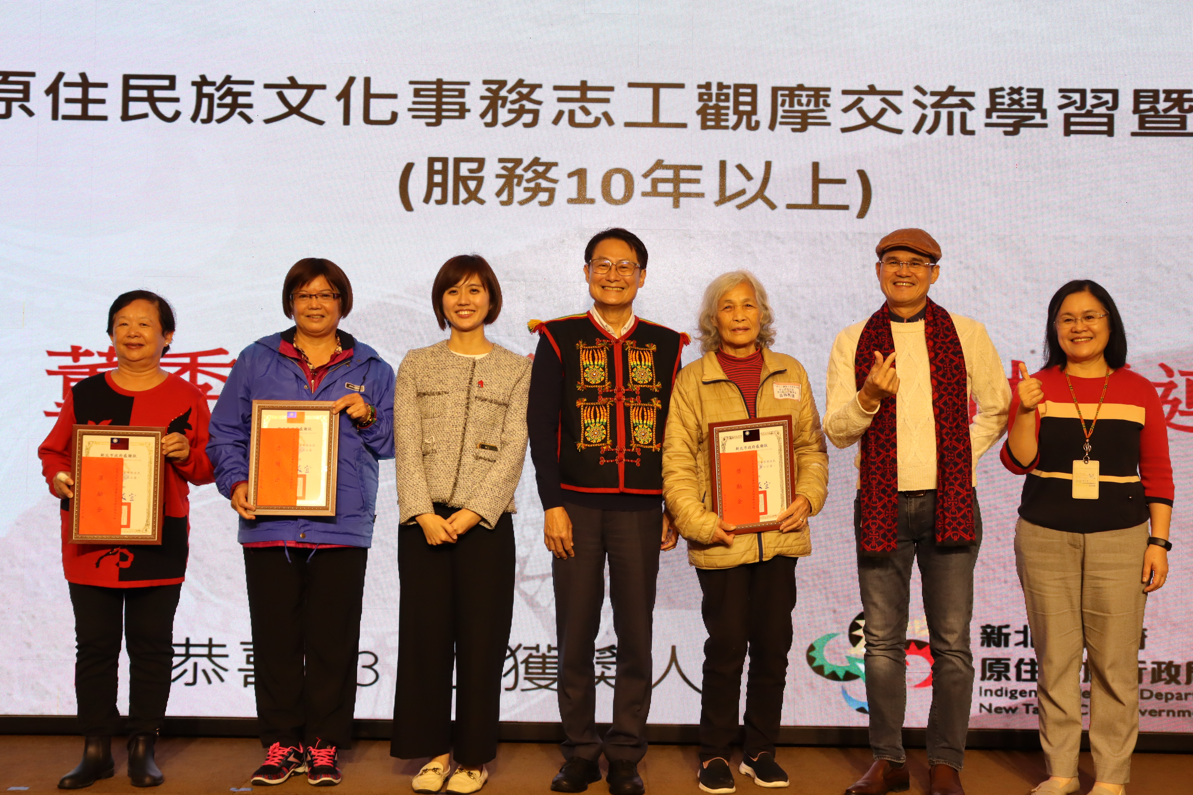 新北市副市長陳純敬頒發感謝狀及獎勵金予服務10年以上的志工。(圖/新北市政府原民局提供)
