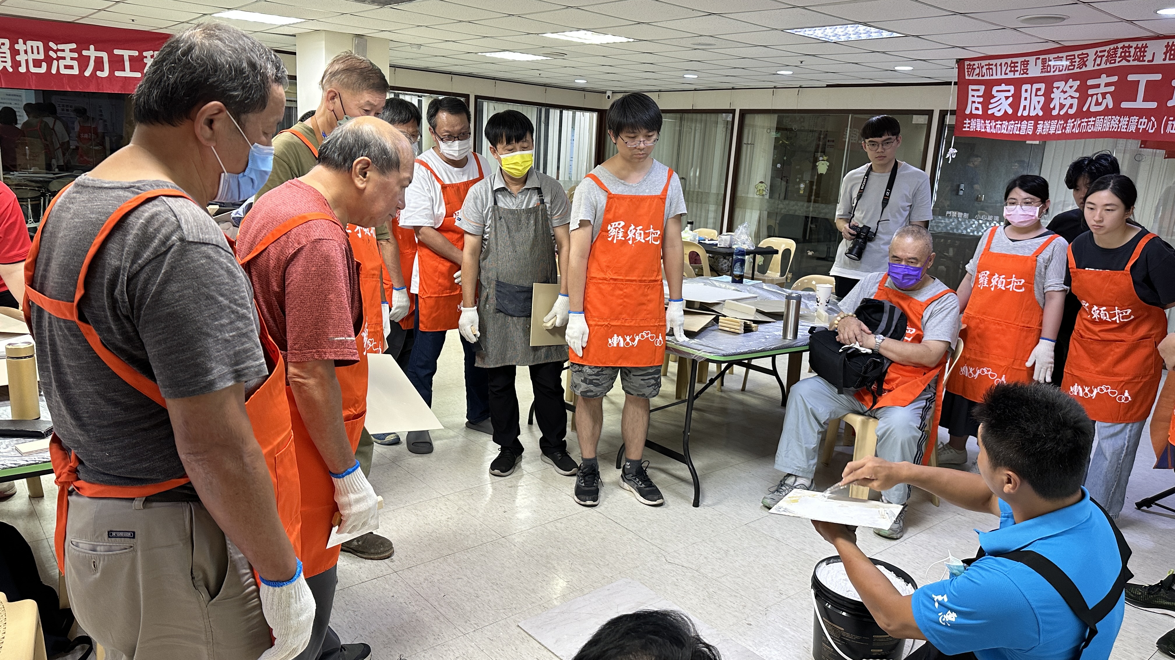 紀天明師傅向志工示範如何用批土補平牆壁的裂縫