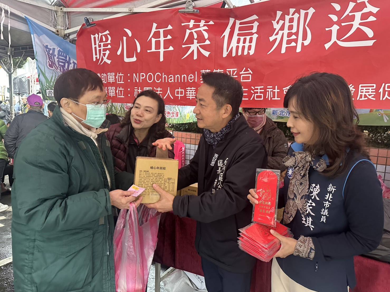  石門區長曾明華（右2）和新生活促進會創辦人羅素如（左2）一起贈送年菜給家戶 市議員陳家琪也致贈紅包袋 祝家戶新年快樂