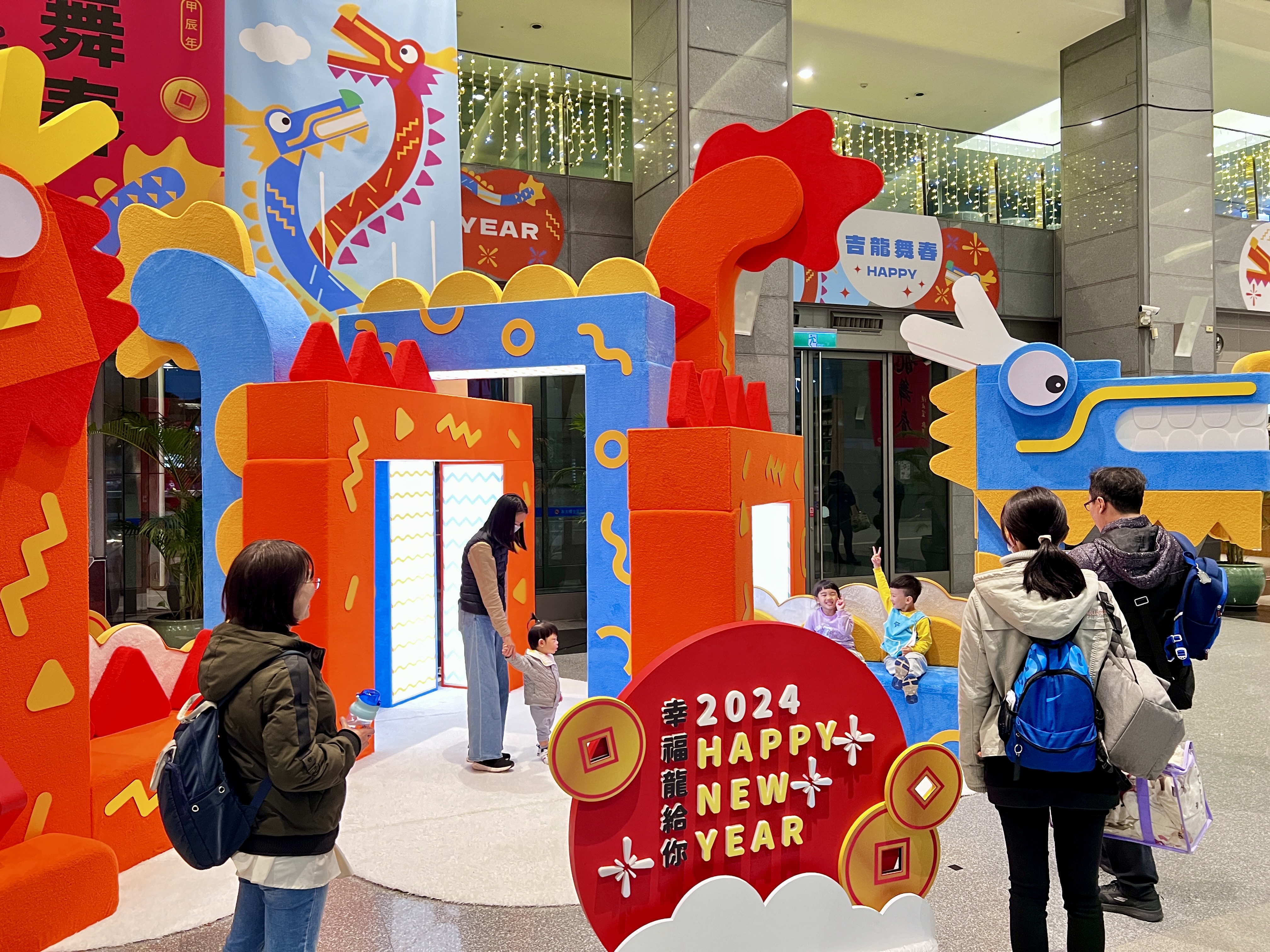 市民朋友帶著小孩在新北市府大樓大廳新春布置拍照、玩耍。