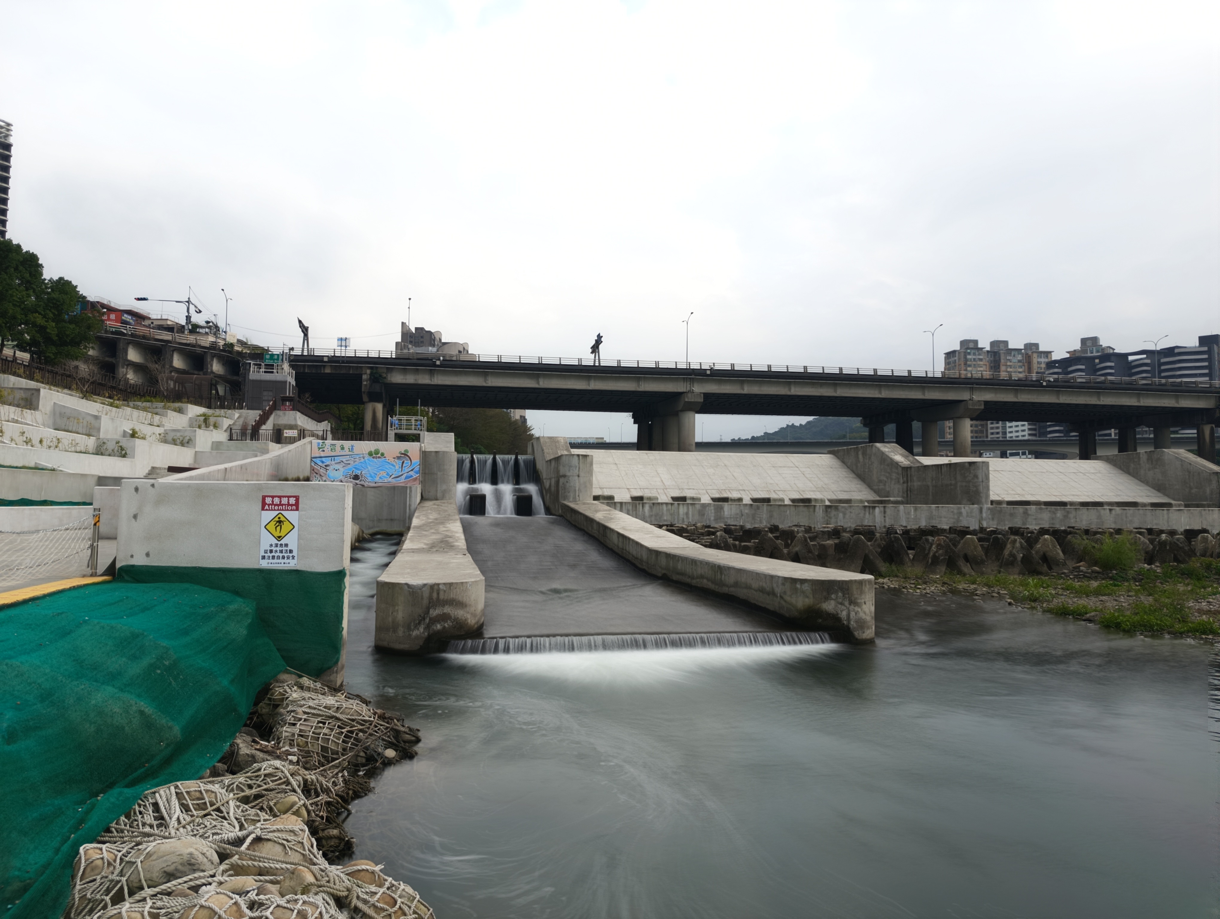 魚道及排放道右岸增設PP繩地工塊石網袋護岸，減少混凝土用量且創造多樣化生態棲息空間