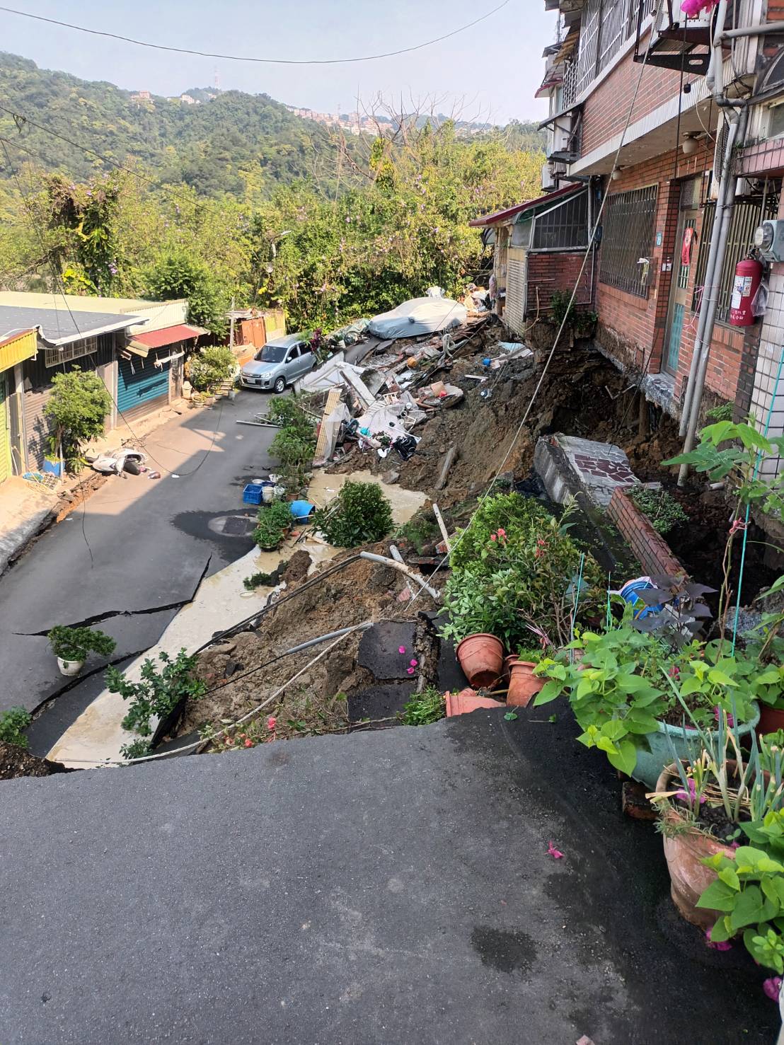 新店安泰路6O巷9O弄住宅門前，因地震造成邊坡坍塌地基掏空，新北市政府除安置住戶之外並進行緊急救災中。