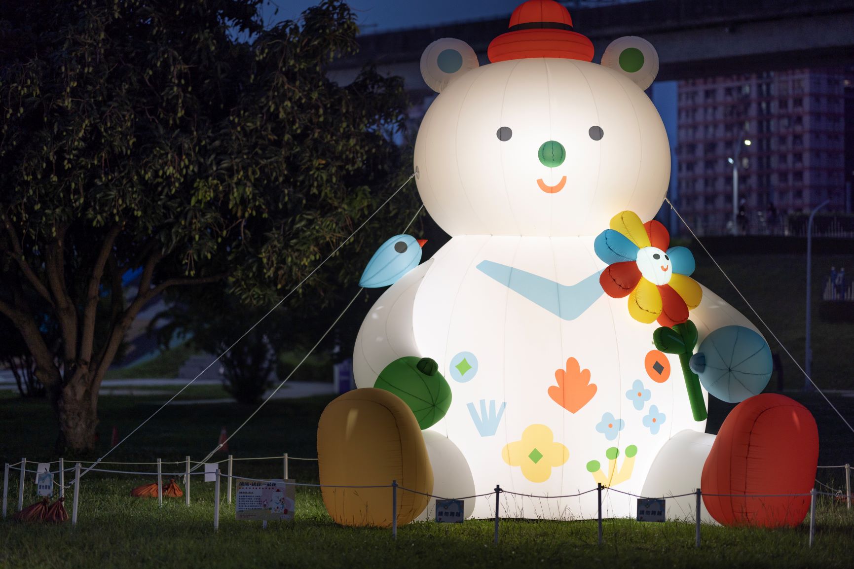 六米高的「幸福熊」和一系列微笑的花朵正在草坪上等你，快帶上野餐墊在草原上，拍一張童趣的照片吧！