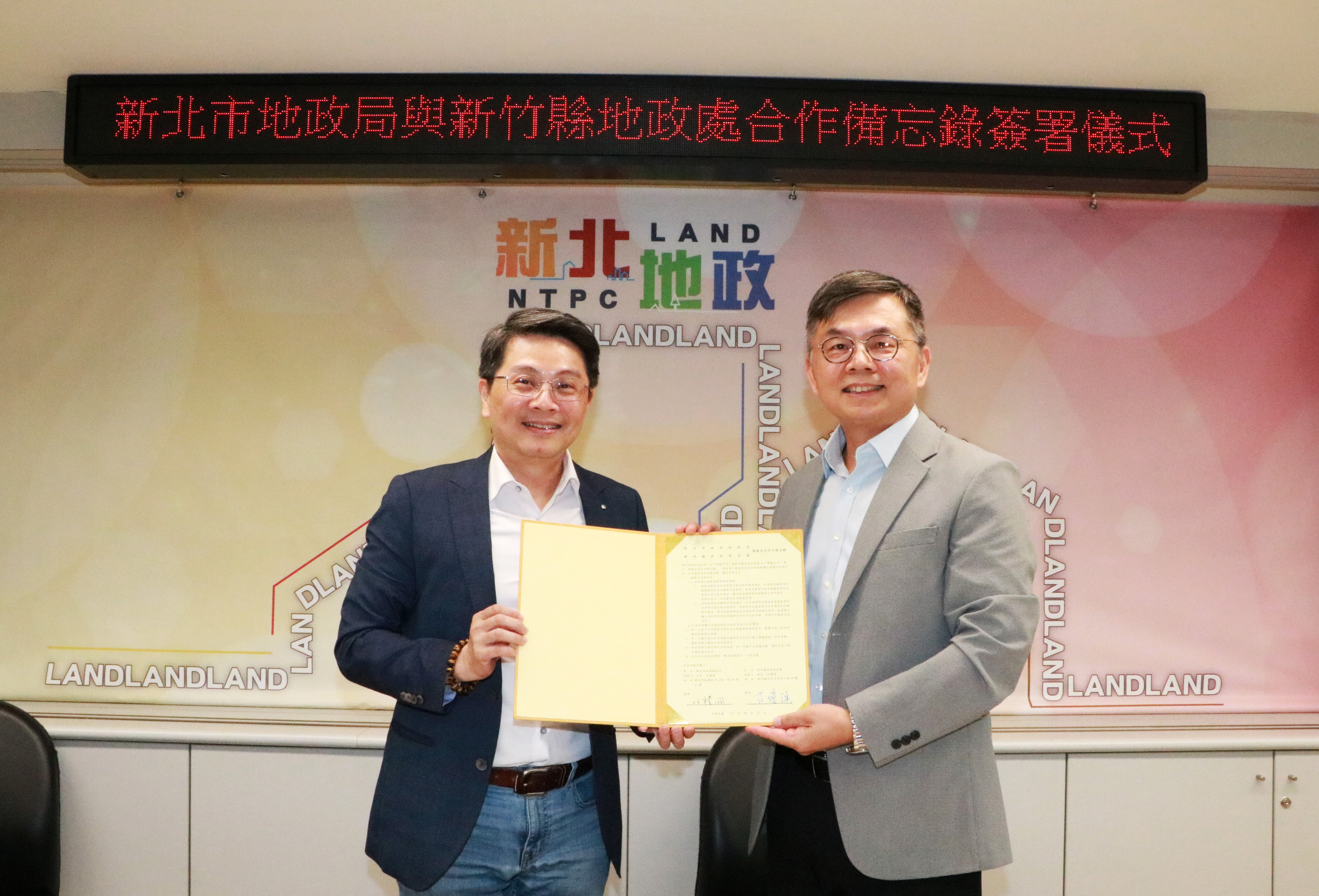 新北市地政局長汪禮國(左)與新竹縣地政處長古瓊漢(右)簽署合作備忘錄。新北市地政局提供