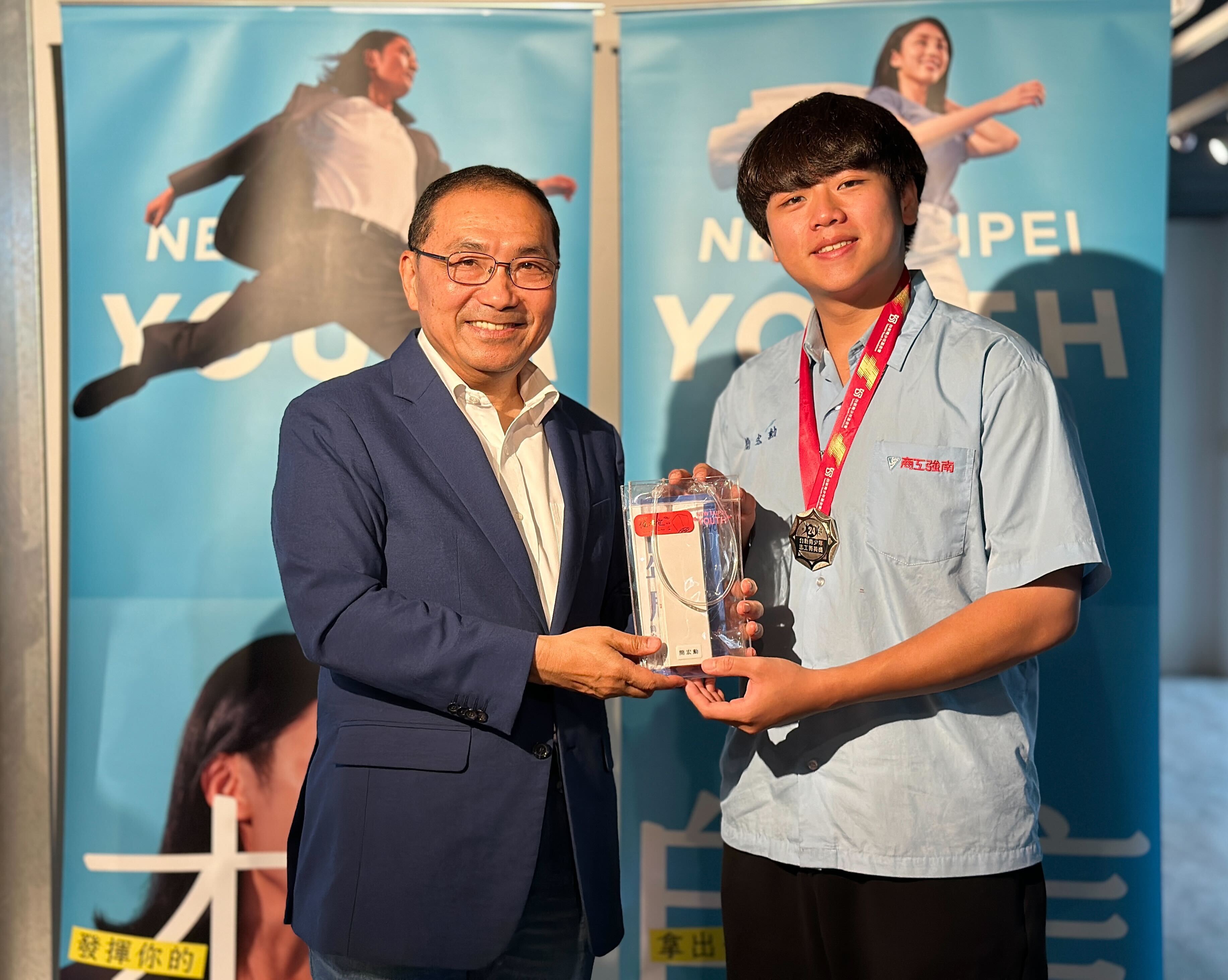 新北市長侯友宜頒贈獎牌予新北市南強工商簡宏勳同學(圖右)
