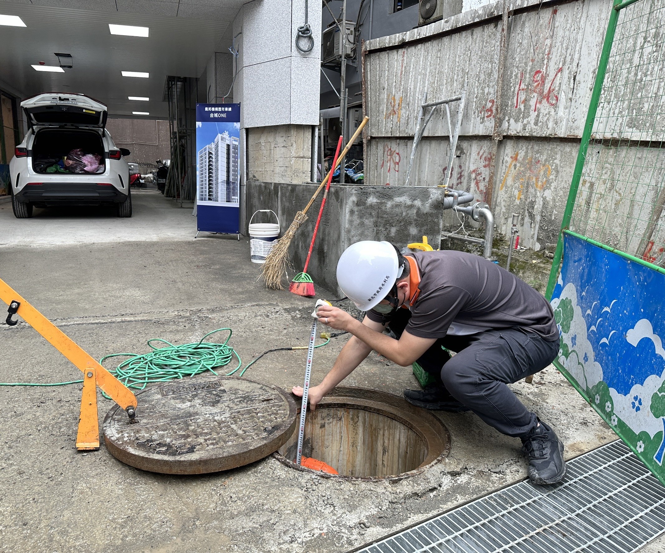 水利局同仁現場查驗量測，確保污水下水道設施高程無誤