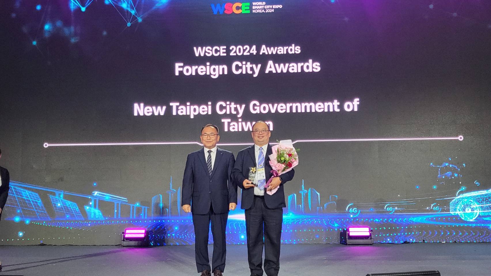 新北市政府出席「2024 WSCE世界智慧城市博覽會暨頒獎典禮」，由資訊中心陳富添主任(右)代表領獎。