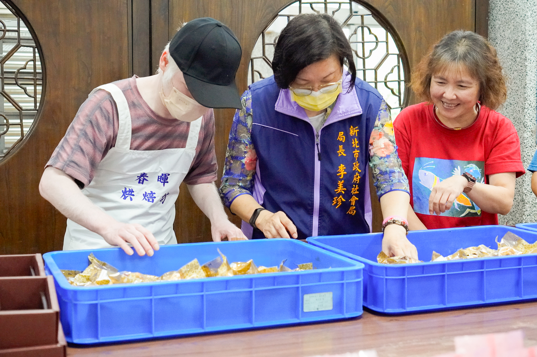 李美珍(中)與身障學員一起將封膜完的食品成品進行分裝