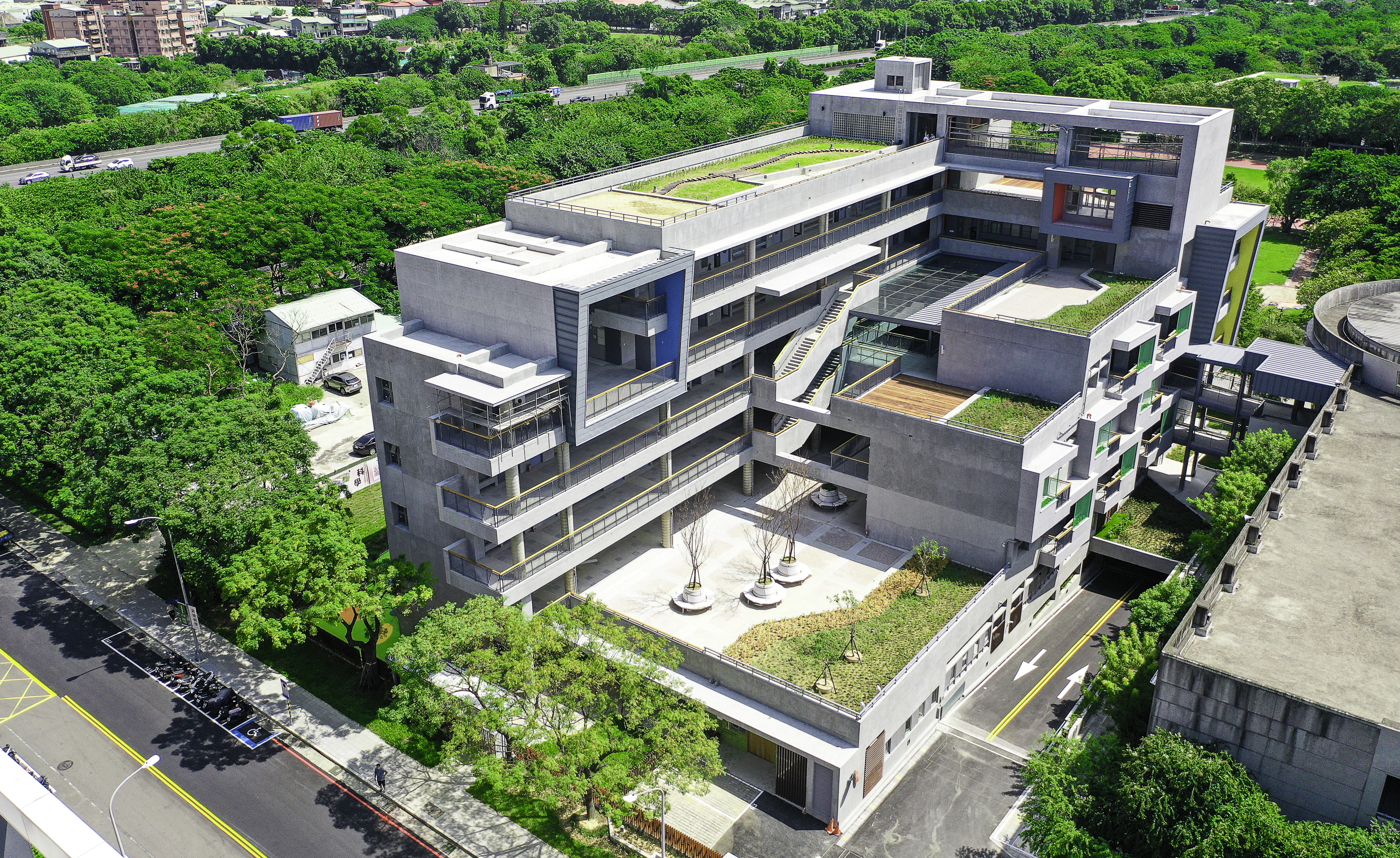 位於北大特區的桃子腳國中小校舍擴建工程完工，第三期校舍延續既有校園的極簡概念，以後製清水模意象展現桃子腳的建築美學，引入周邊綠景的視覺體驗，期望提供全體師生更好的校園環境。