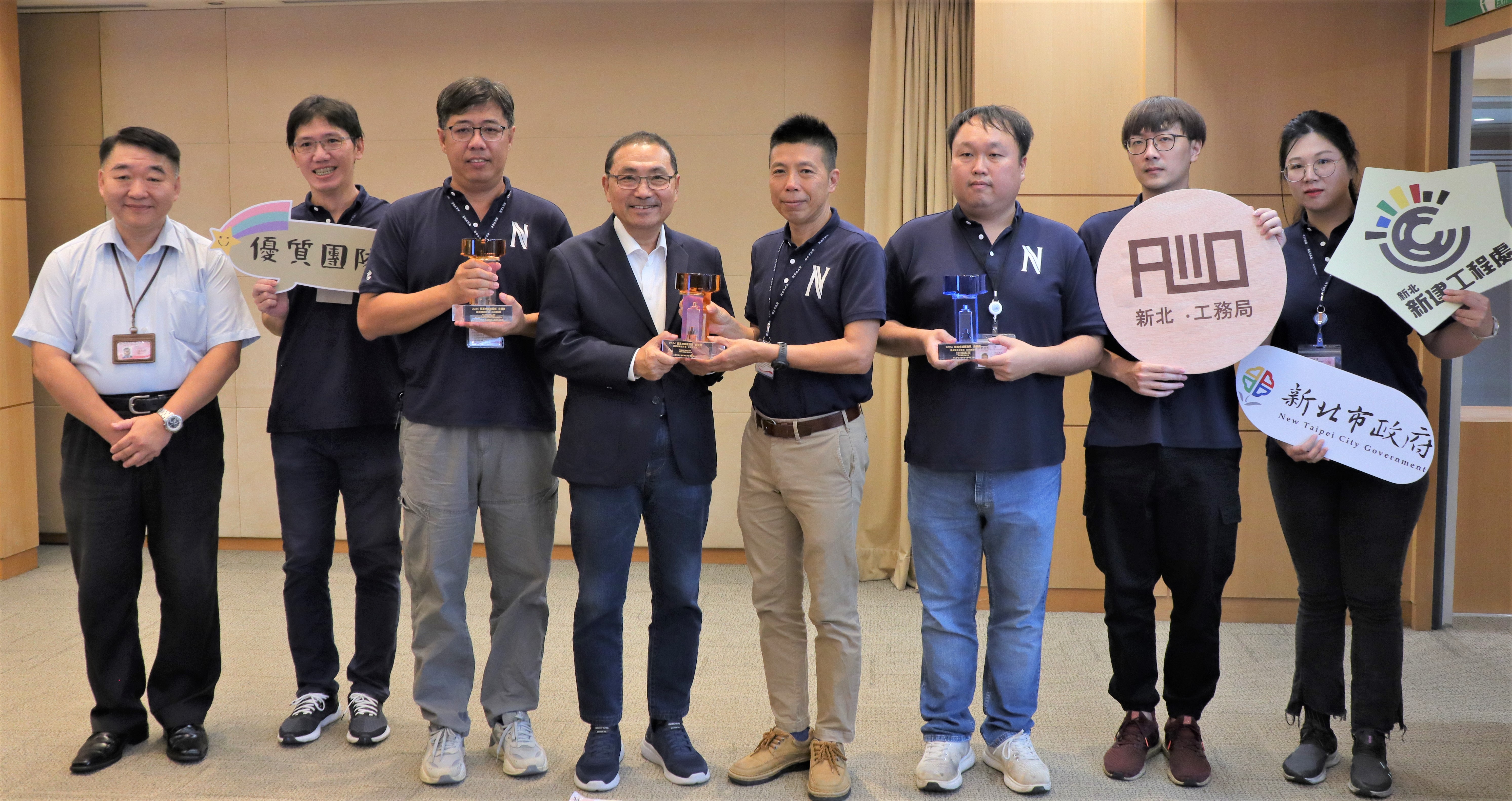 新工處代辦三項工程榮獲「國家卓越建設獎」，工務局長馮兆麟(左)陪同獲獎同仁在市政會議中分享榮耀，由副處長李仲昀(右四)代表獻獎。