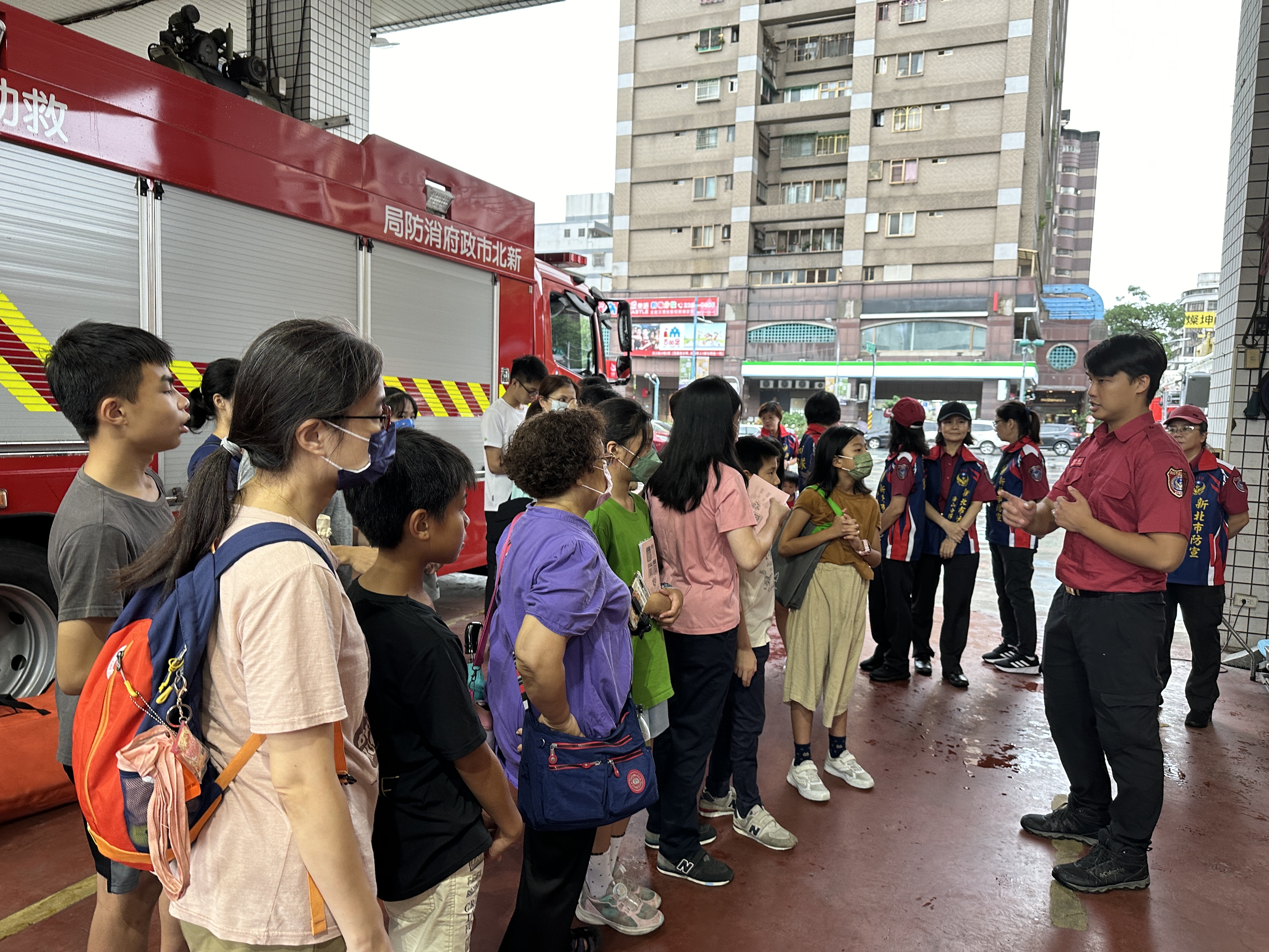 消防員向家庭志工介紹消防設備，以及消防員和義消工作內容