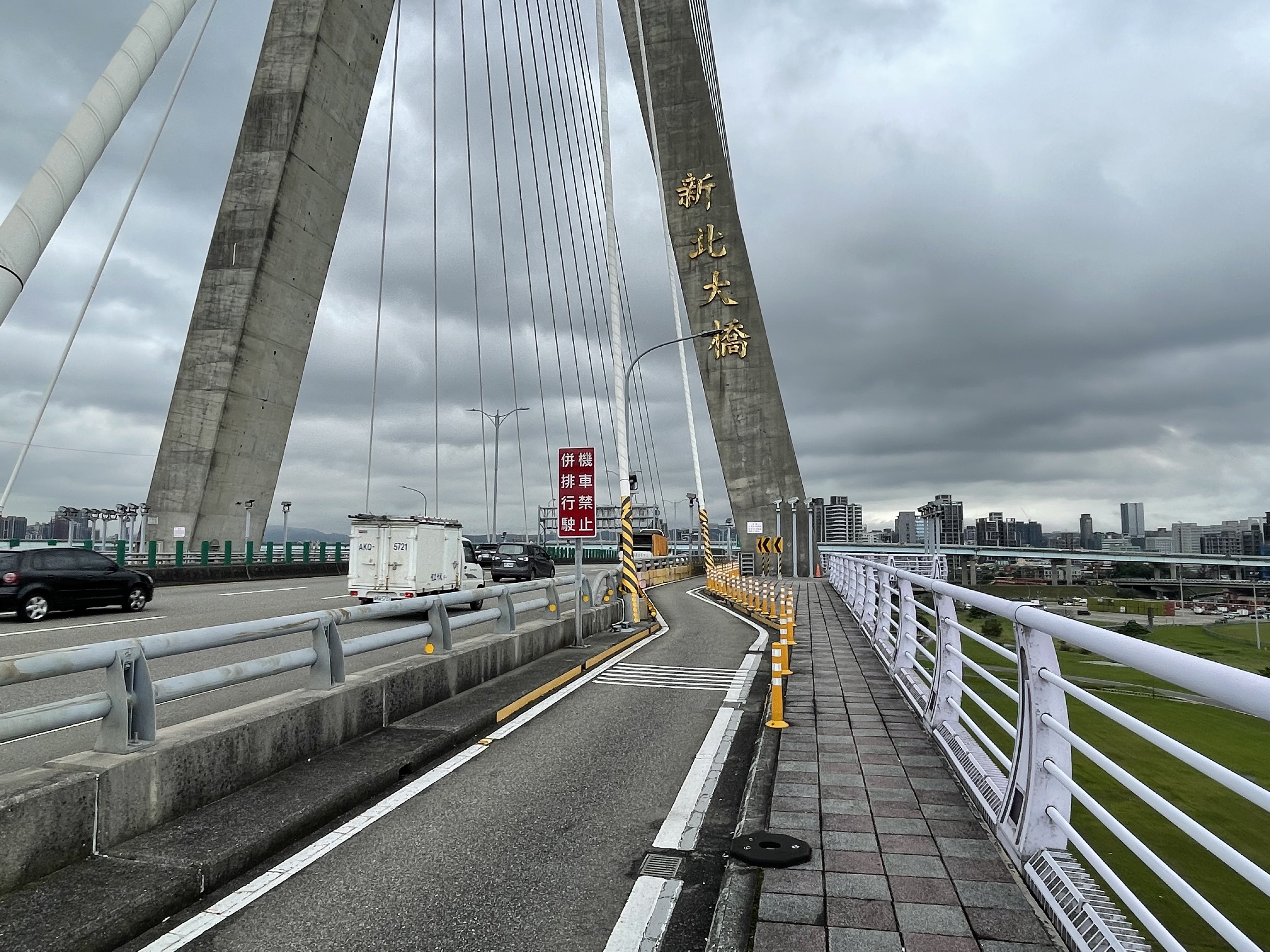 新北市政府為提供機車族安全的通行環境，將針對新北大橋橋塔旁S型彎道進行改善，圖為現況照。