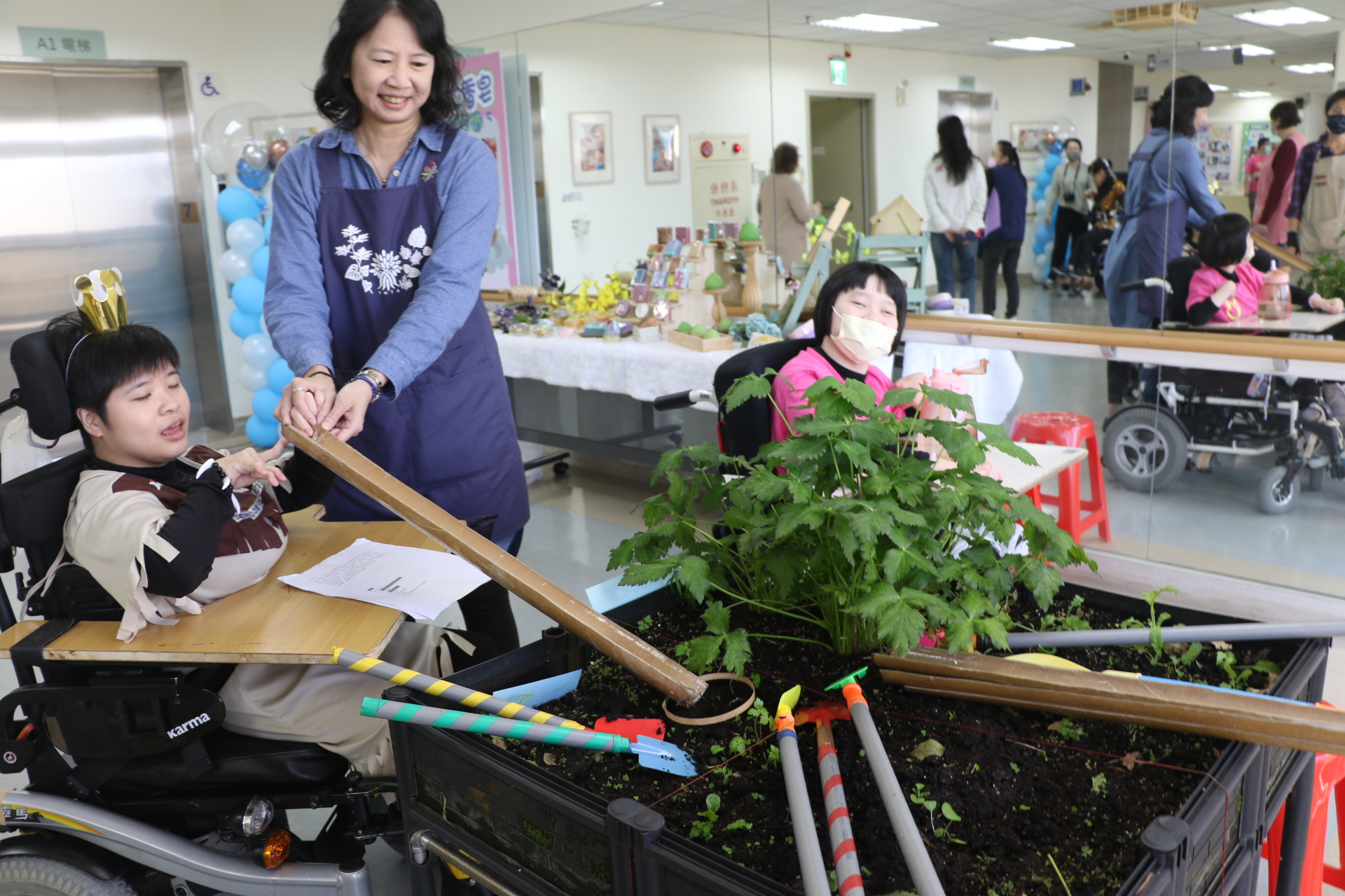 台灣園藝輔助治療協會理事長張博然利用剖開的海報筒讓翁彥如播種