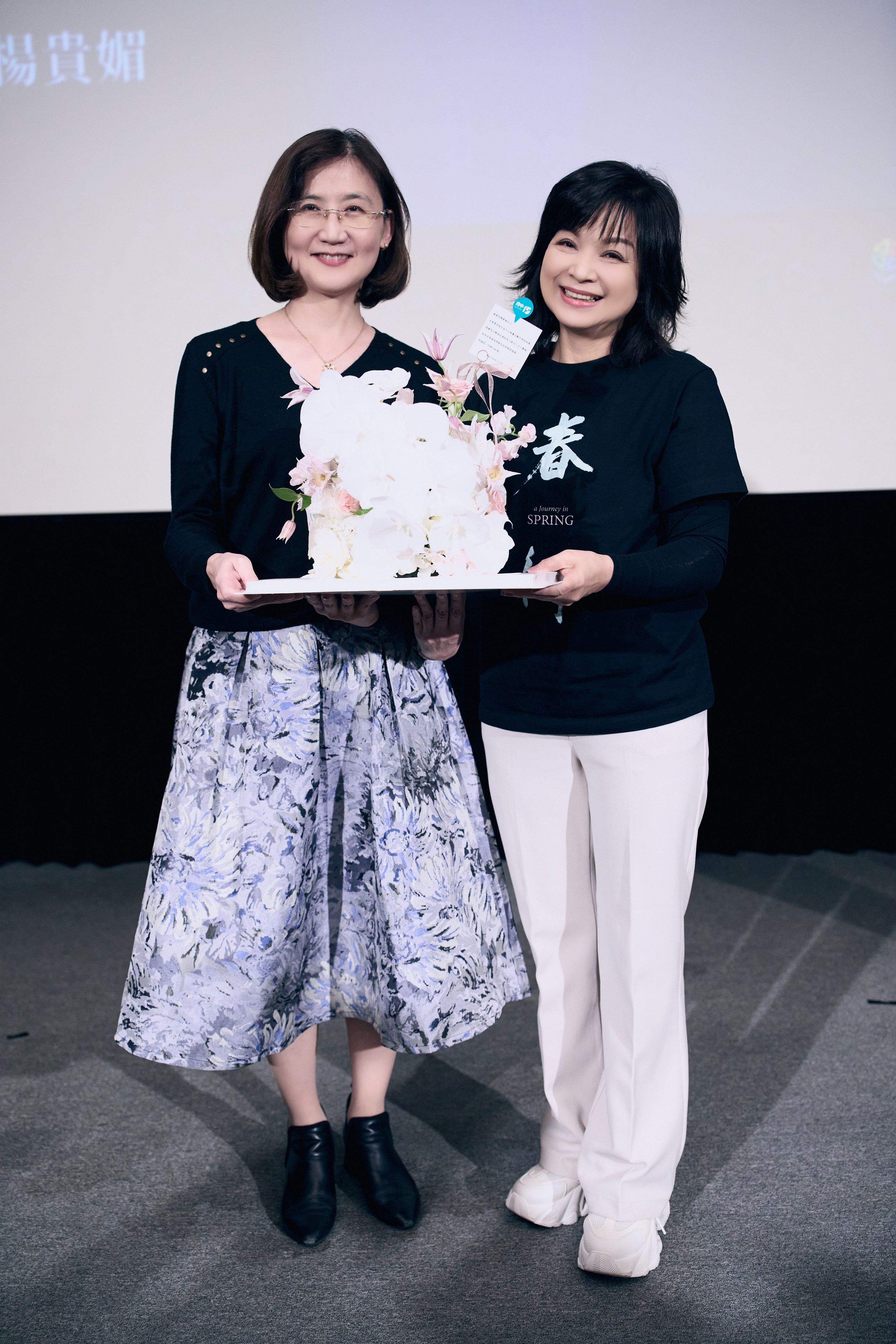  新北市政府文化局張䕒育局長（左）致贈府中15十三週年館慶蛋糕花禮給「館慶一日大使」楊貴媚（右）