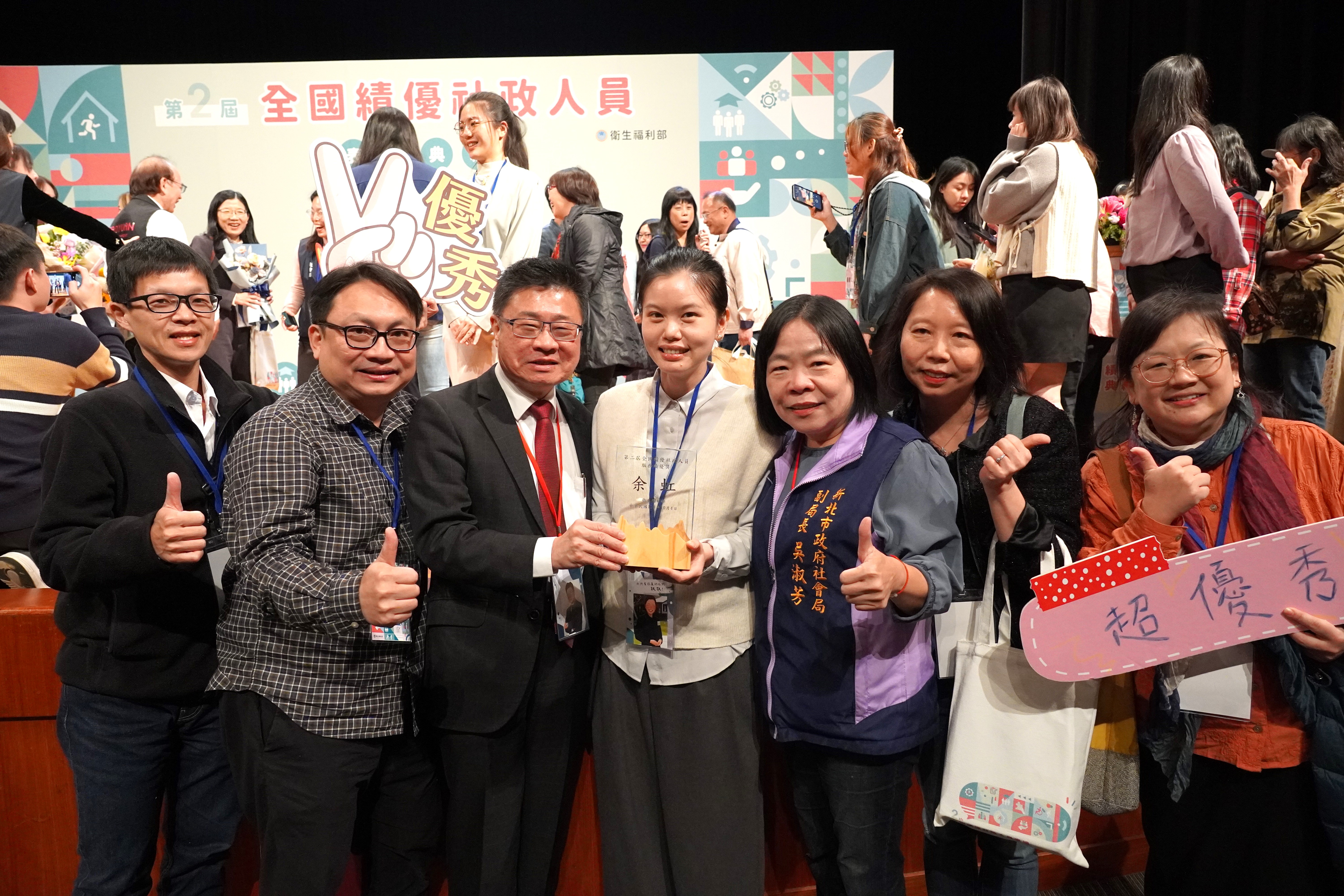 113年全國績優社政人員表揚，新北市八里愛心教養院余虹(中)獲頒「服務績優獎」，社會局同仁齊聚典禮為她祝賀