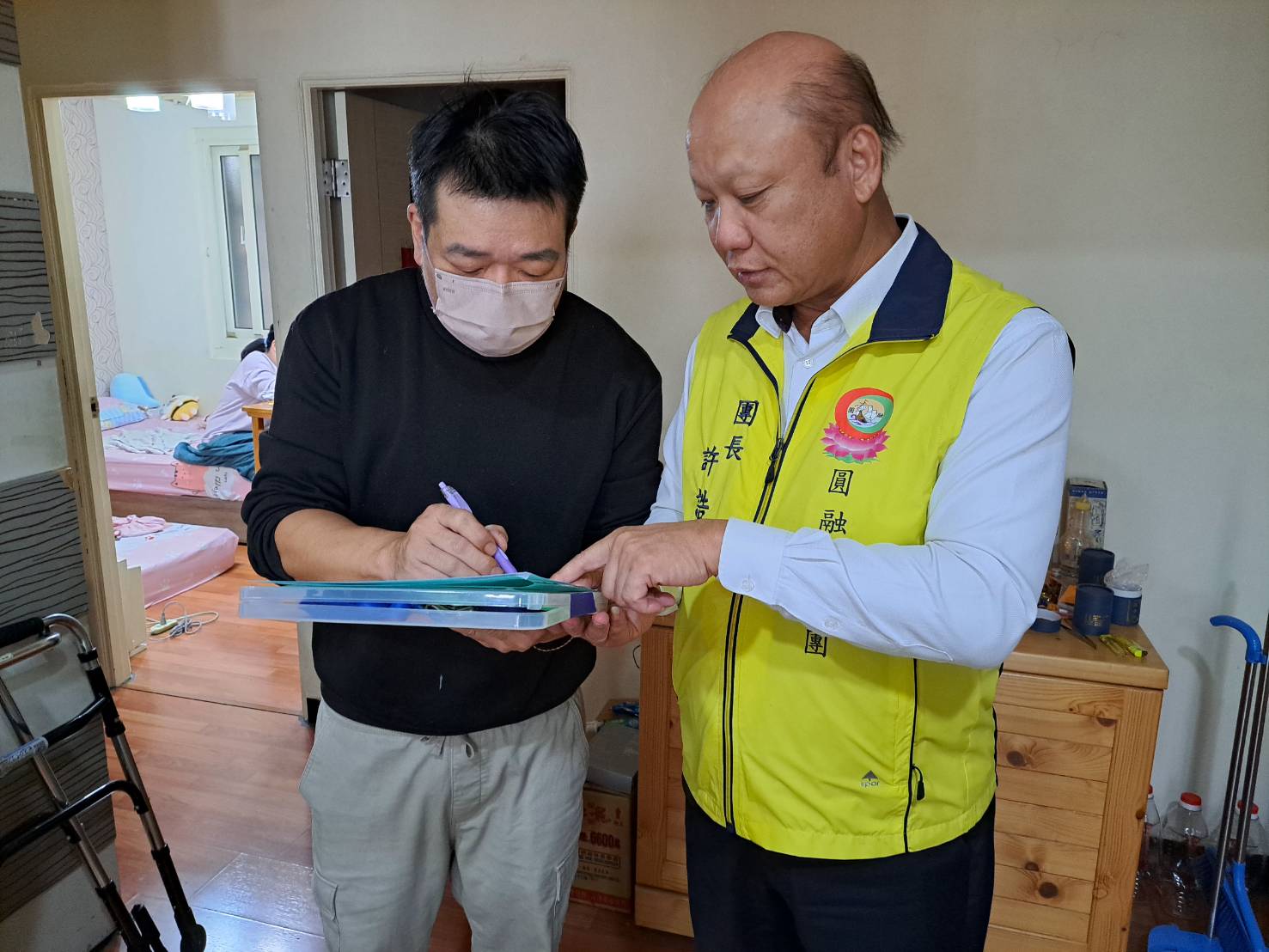 許誥將行善團1人1千元的捐贈名單及善款交由卓父簽收