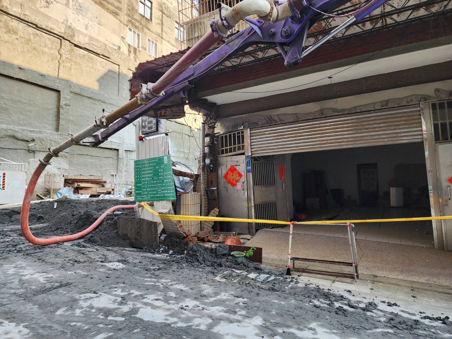 圖說： 三重區六張街建案基地開挖不慎造成嚴重損鄰案件，新北市政府工務局在第一時間勒令停工，迅速進行搶災作業，圖為採取灌漿作業。