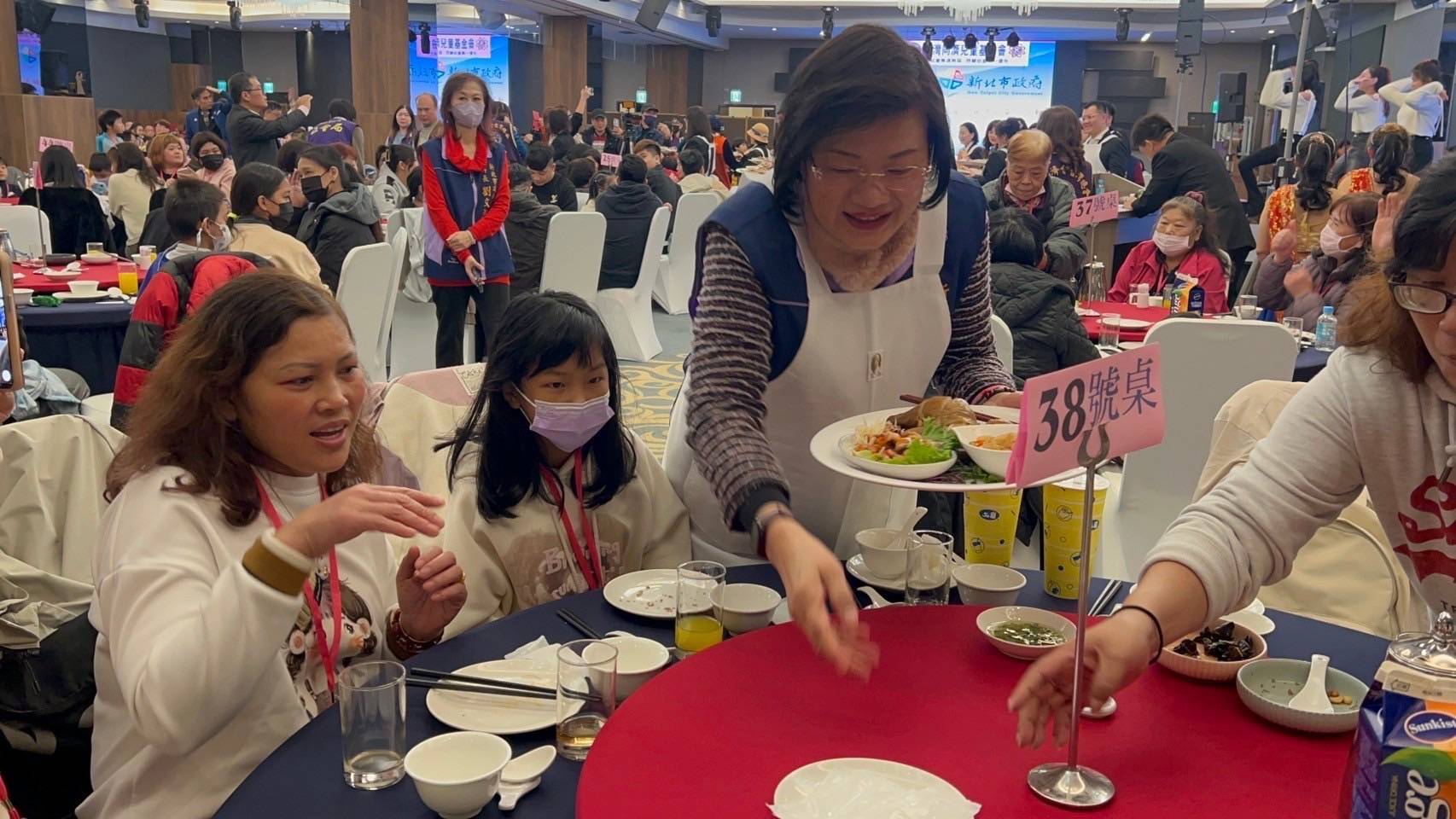 社會局長李美珍上菜給參加圍爐的家庭和小朋友