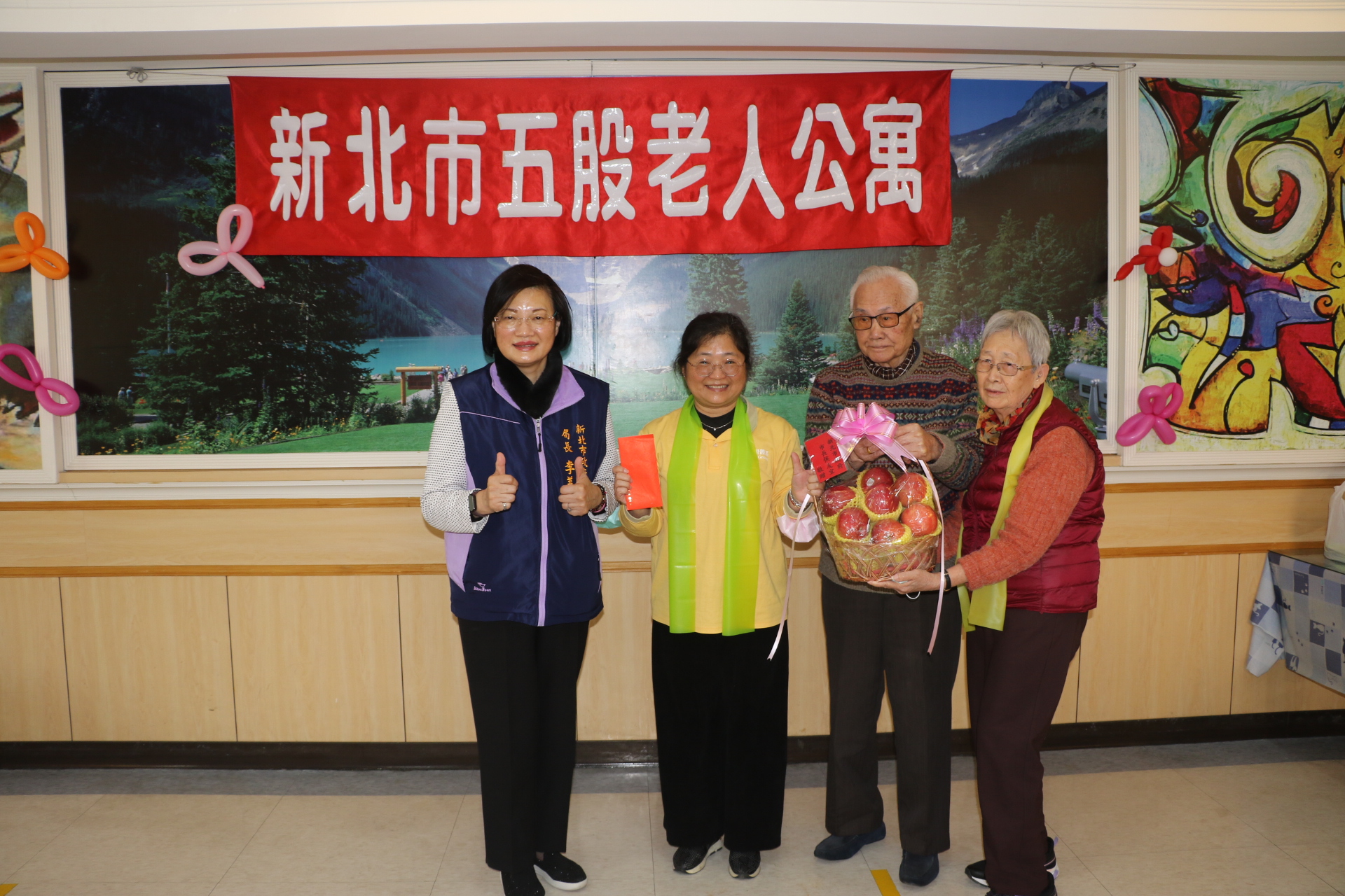  李美珍局長代表侯友宜市長致贈加菜金和蘋果給五股老人公寓長輩 由沈允覺和太太劉志新代表受贈