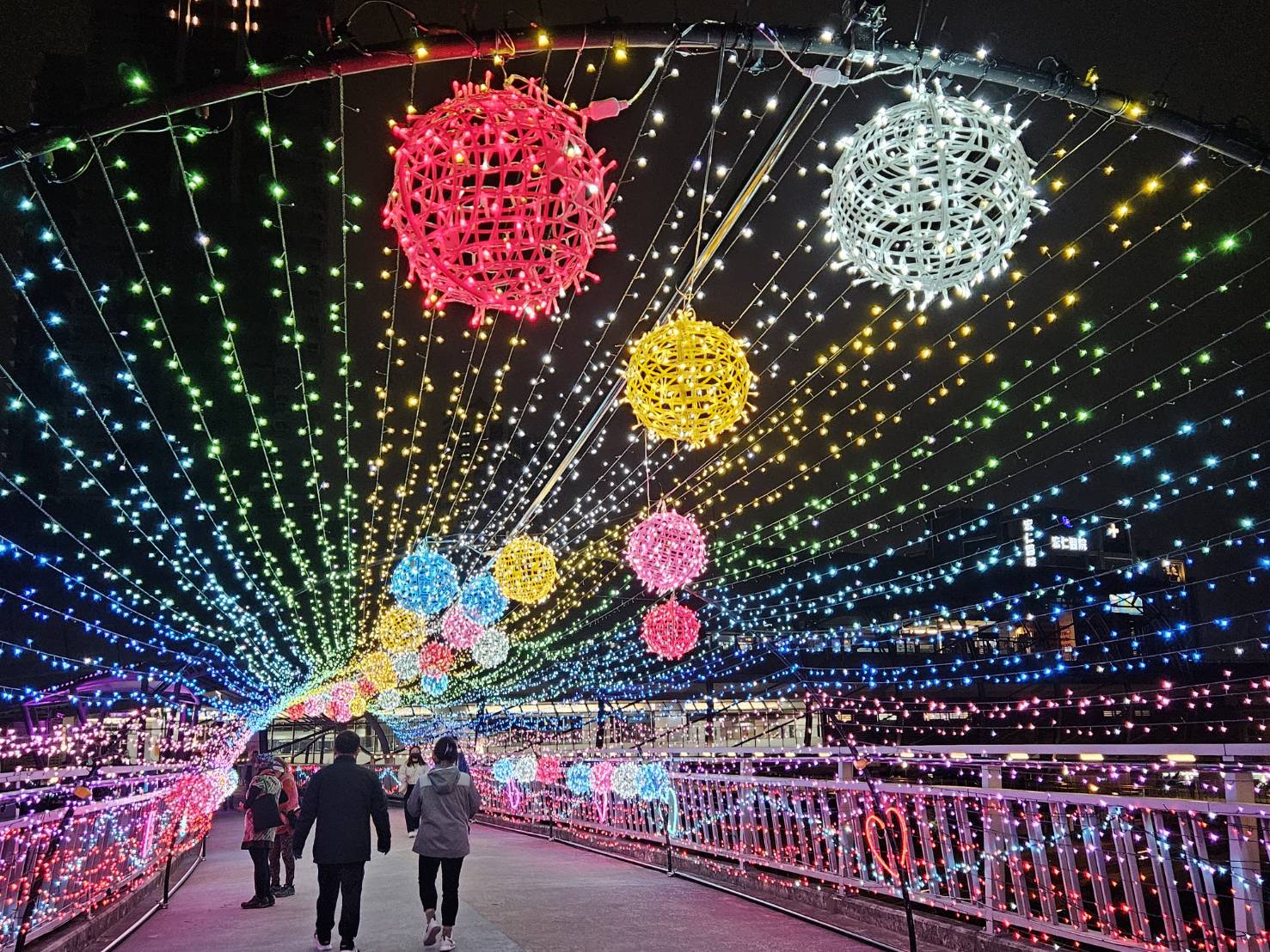  拱型的炫彩光廊中，七彩的星星燈點綴著情人節的夜空