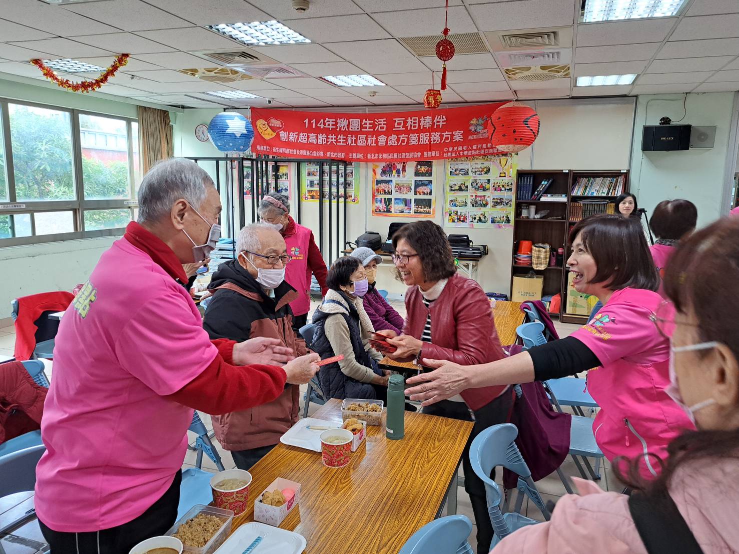 社會局副局長許秀能代表侯友宜市長致贈每位長者蛇年小福袋 右為民權社區發展協會執行長邱秀蘭