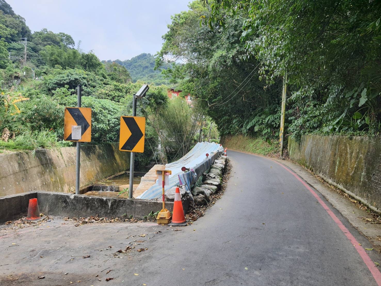 施工前邊坡滑落，以鼎塊補強且堤頂僅單車道、會車困難