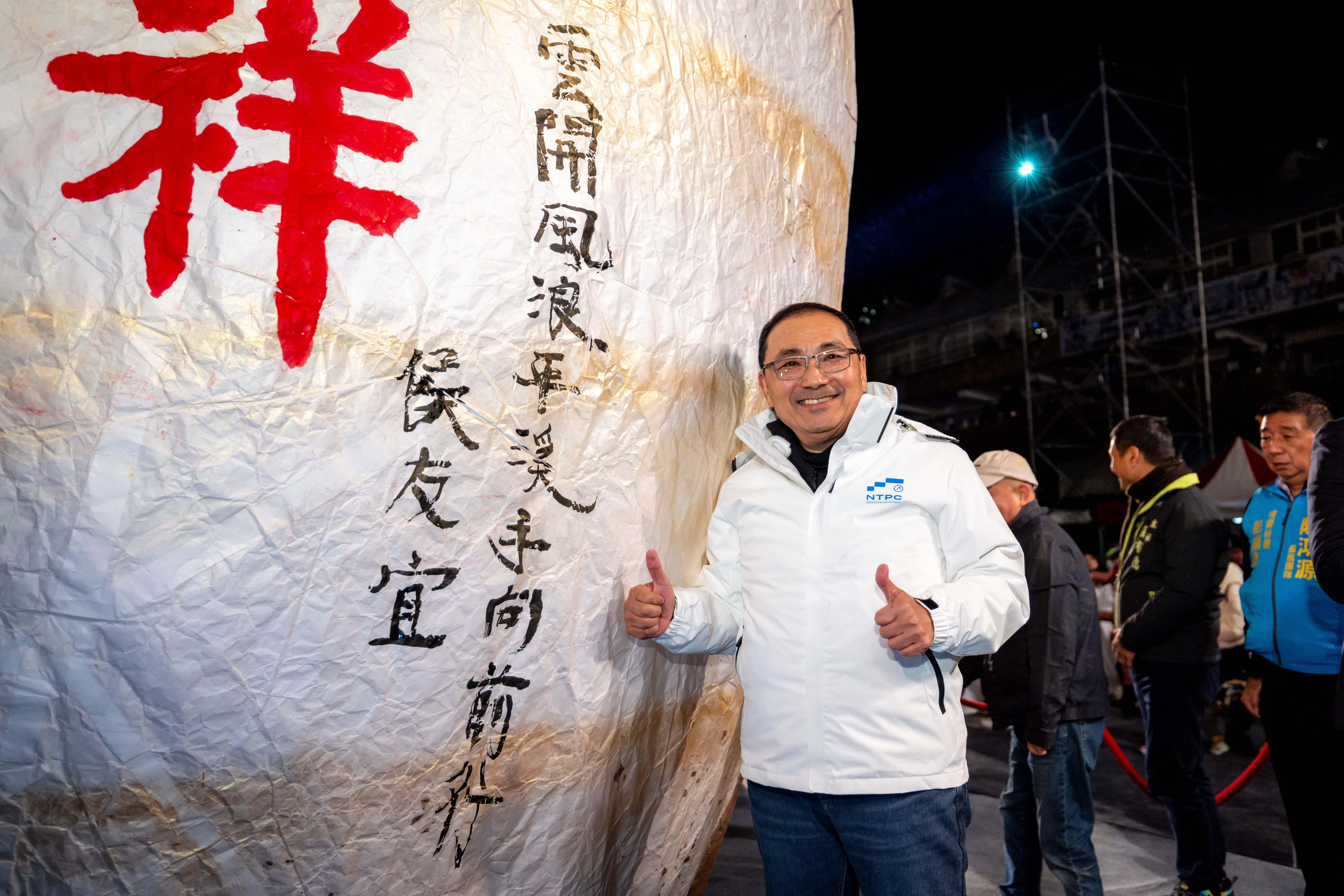 新北市市長侯友宜在蛇年金蛇造型主燈上落款題字「雲開風浪平 溪手向前行」。
