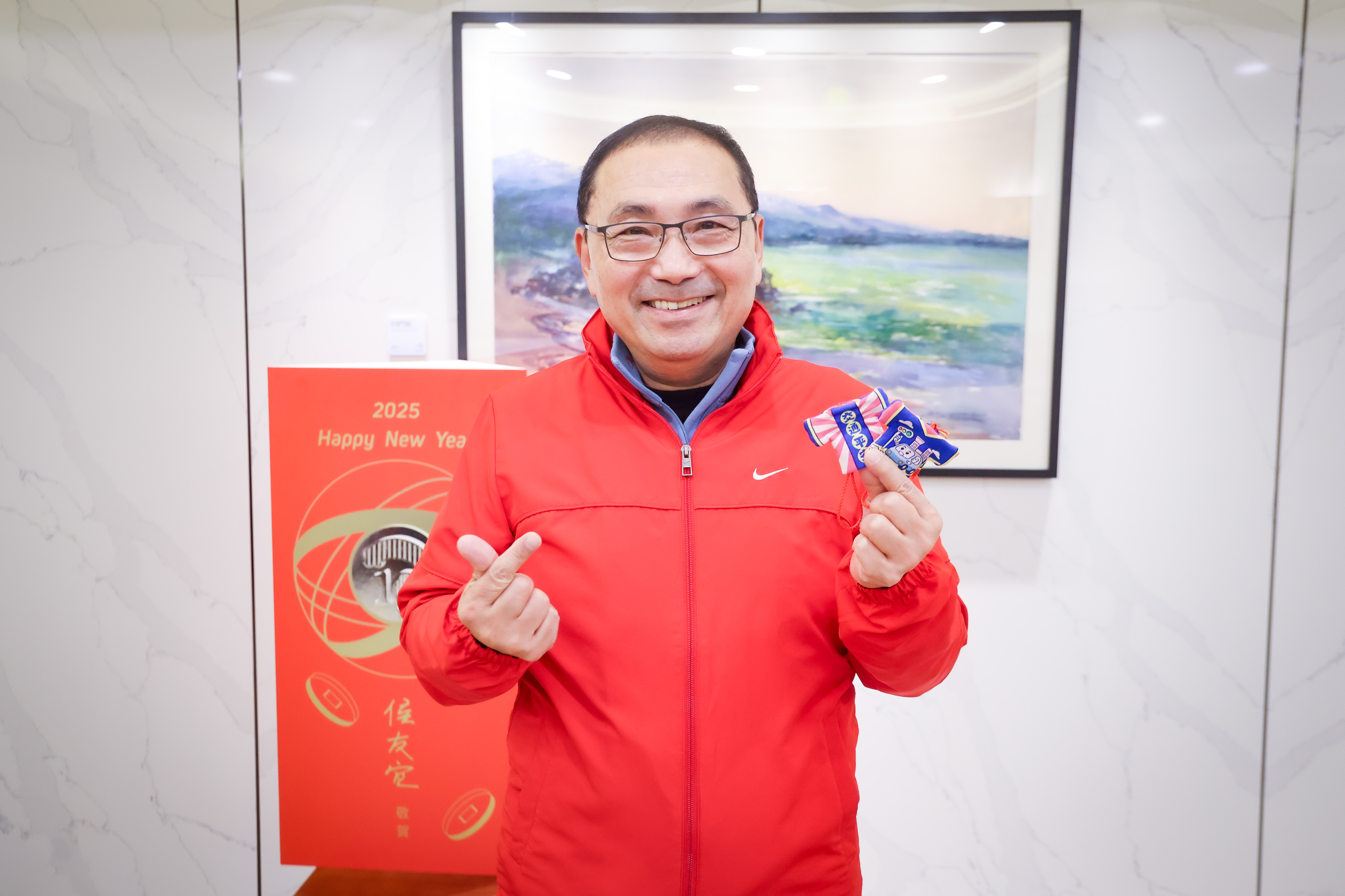 市長侯友宜親自拿著小神衣向民眾拜晚年，提醒民眾注意交通安全。