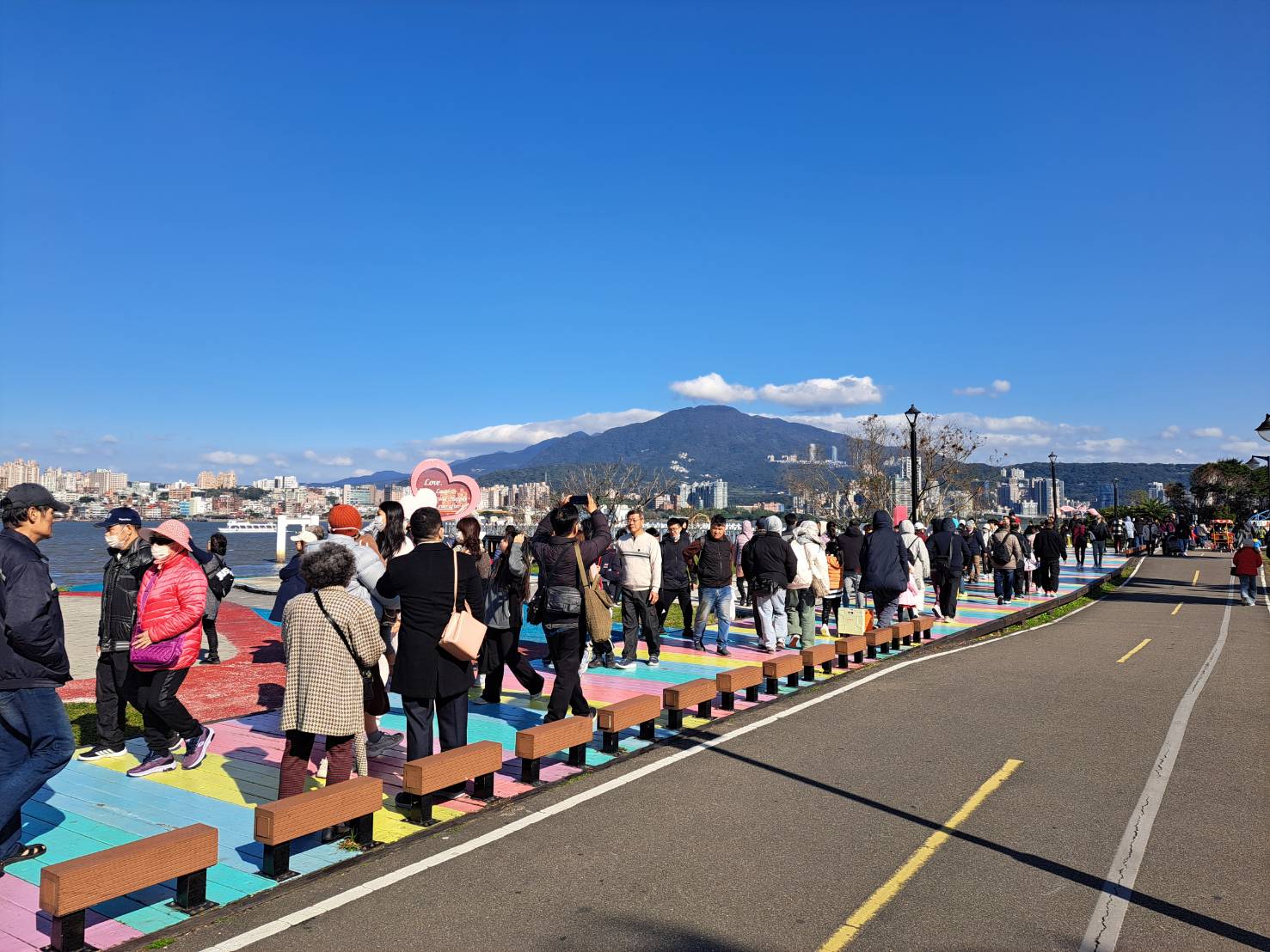  眾多遊客行經八里左岸公園彩虹步道