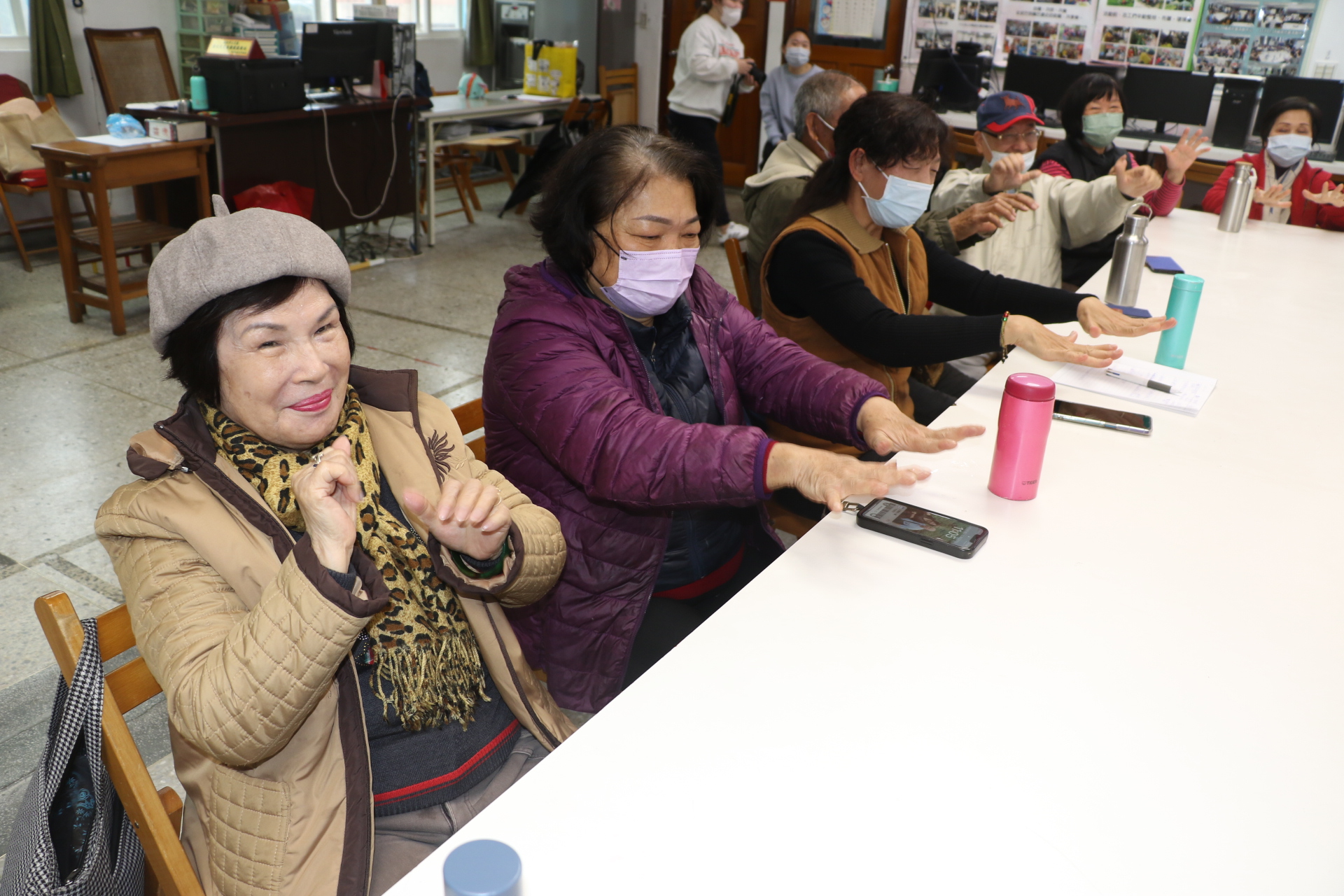  三芝福成社區長輩在老師的指導下 練習平舉換手勢 以訓練反應力和專注力