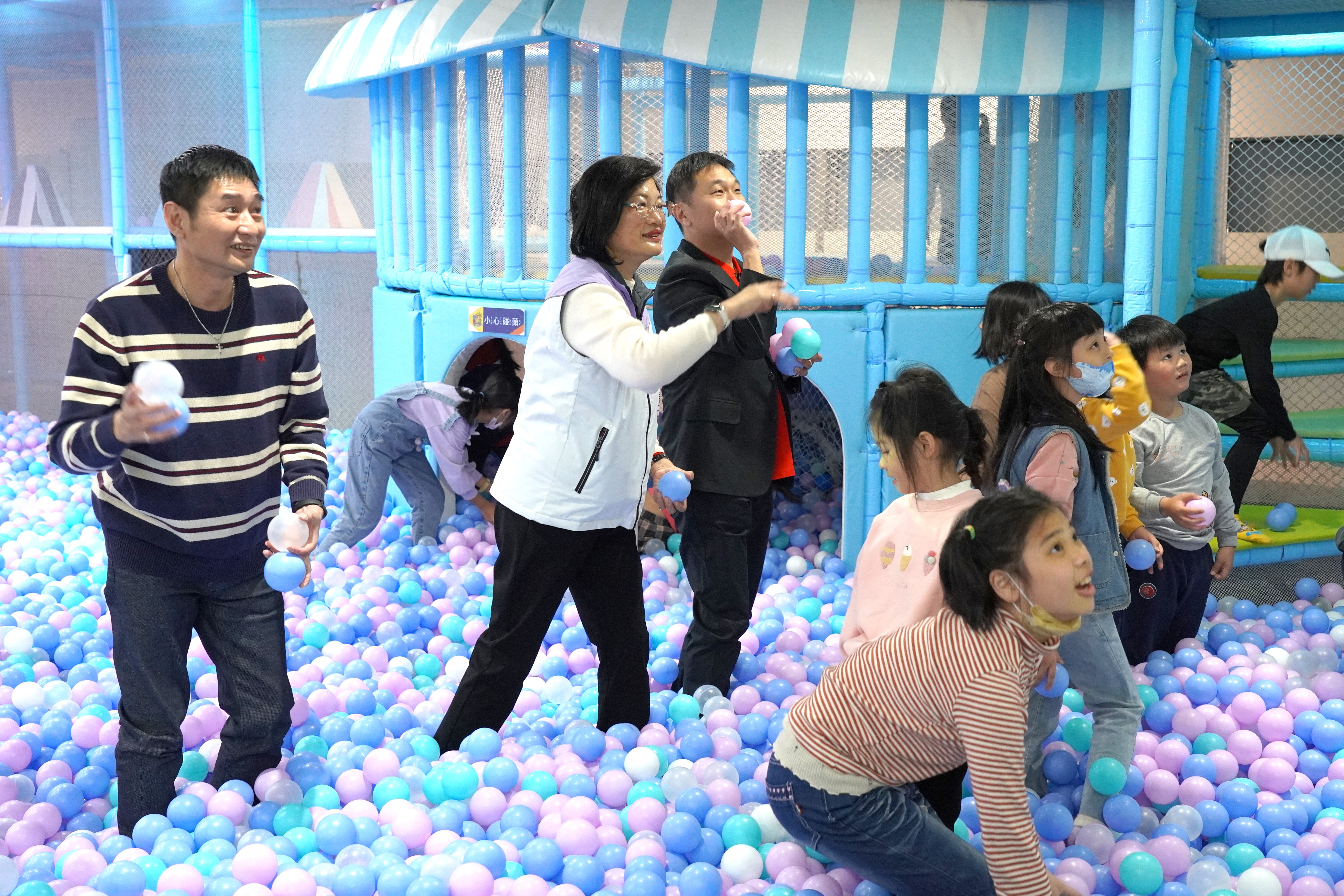 看著孩子們在球池內丟球闖關玩得開心，社會局長李美珍及板橋中山店業務促銷室副理王翔新(左3)和追風奇幻島營運部督導林樹輝(左1)也加入一起體驗遊戲