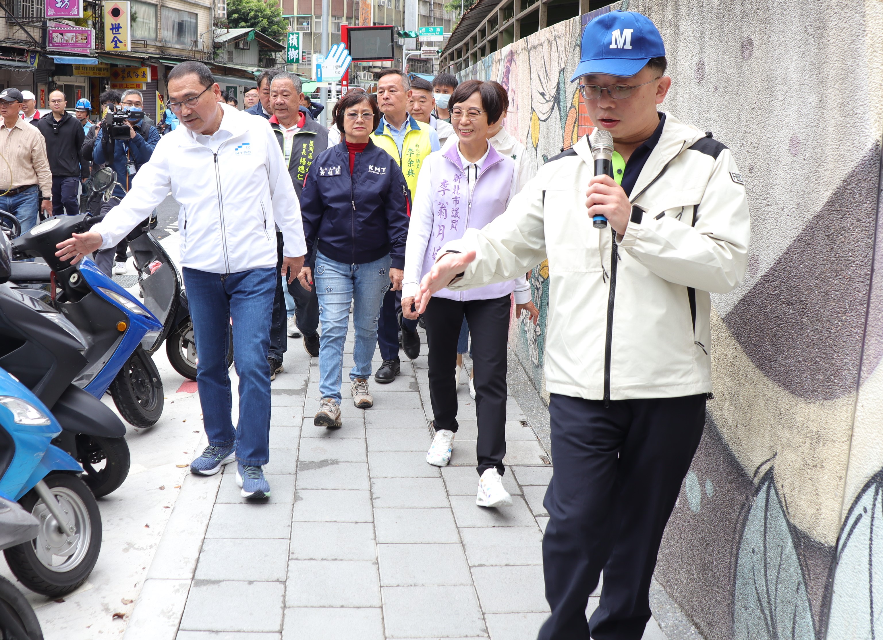 侯友宜市長(右四)今日前往視察蘆洲國小通學廊道完工現況，並親自體驗完工後寬敞又平坦的人行道，養工處長鄭立輝(右一)在旁陪同導引說明。