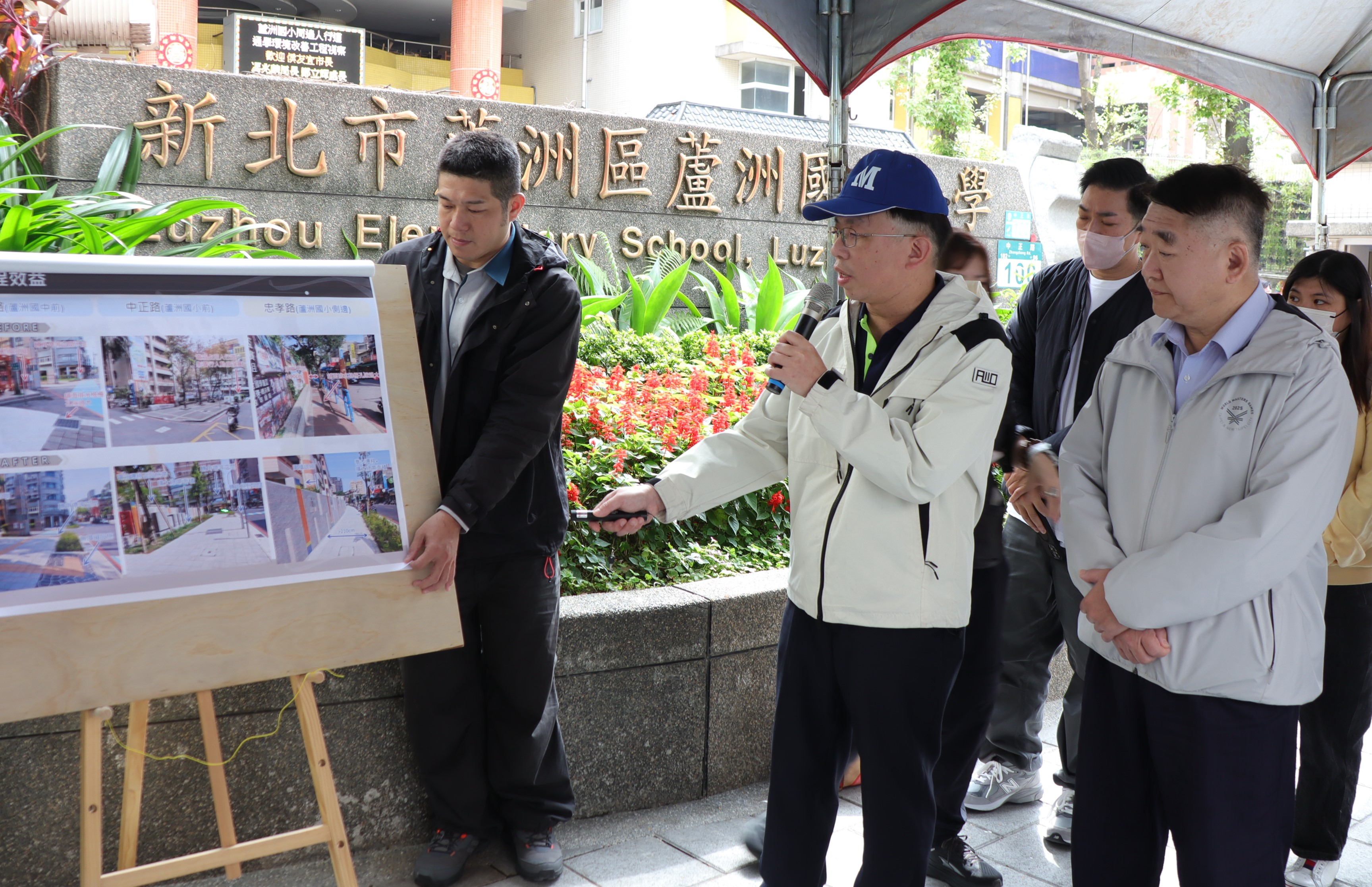 養工處長鄭立輝(右二)說明蘆洲國小周邊人行道及通學環境改善成果，新北市政府工務局長馮兆麟(右一)也在場聽取簡報。