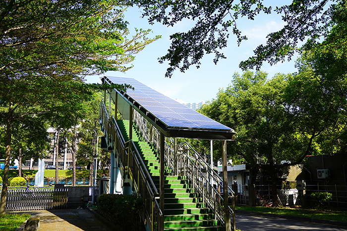 明志科大勇於創新，在校園天橋上成功建置太陽光電系統，此舉為全國校園首創，過程中雖克服諸多挑戰，但成果豐碩，以校園微電網具體實現淨零校園的願景
