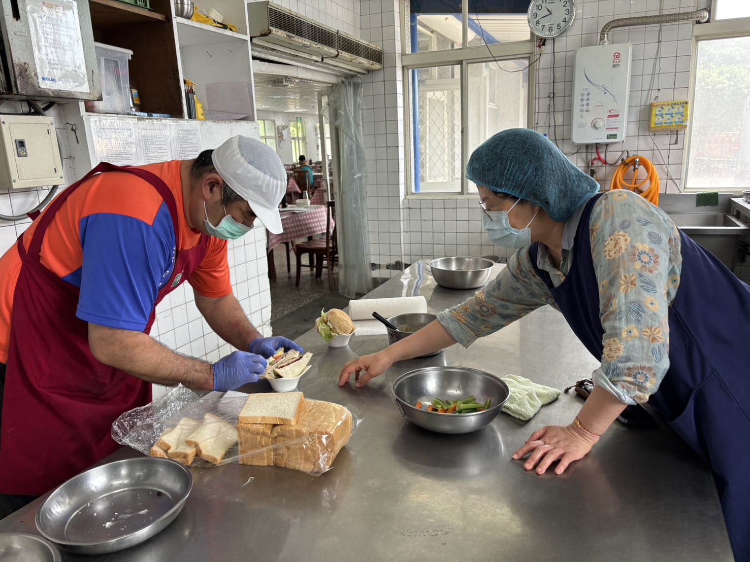 尉遲君（左）和營養師陳雅君在廚房為長輩準備西式早餐三明治和漢堡
