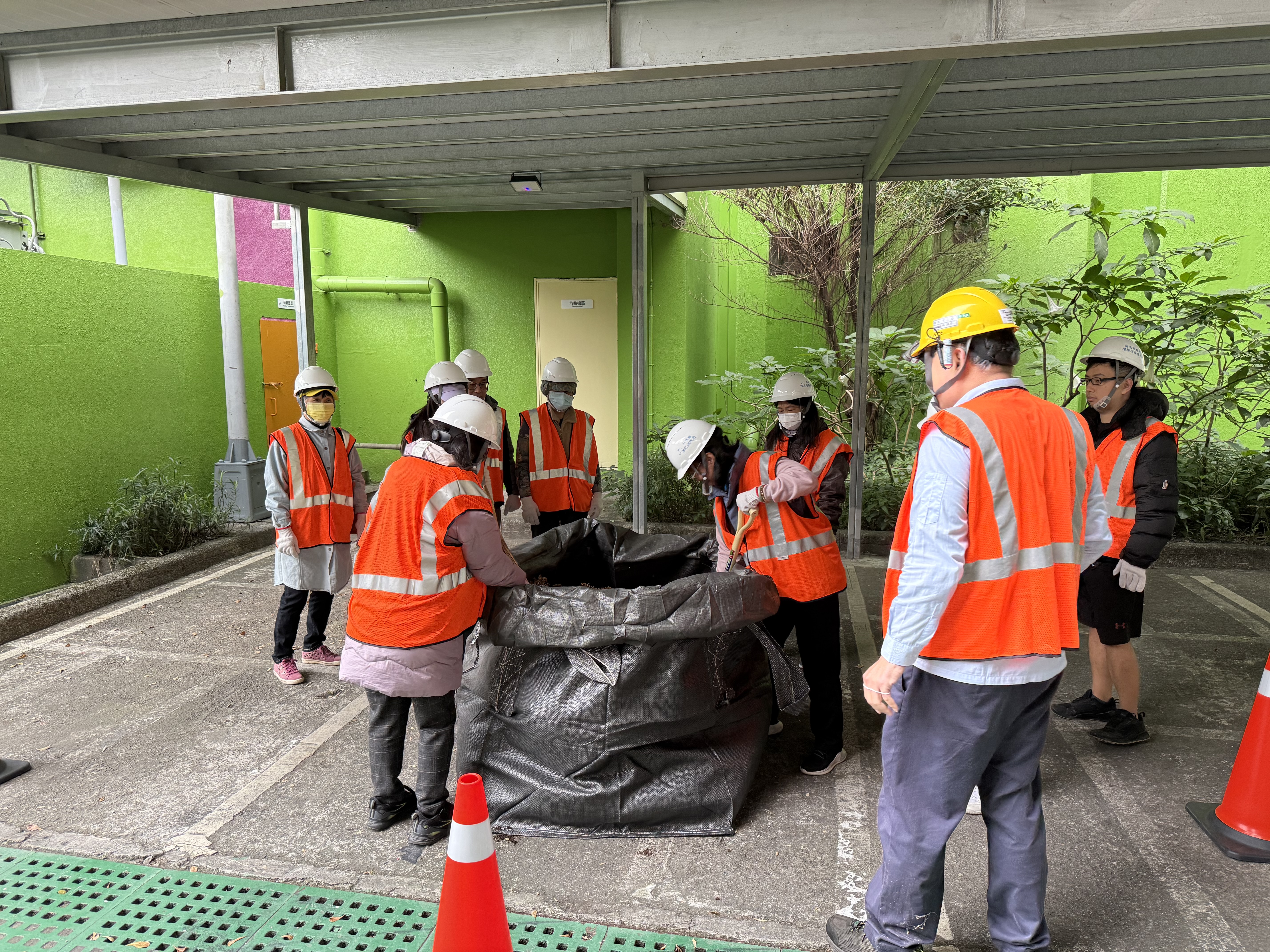 民眾體驗運用回收的咖啡渣與木屑混和堆肥，於廠內製成肥料