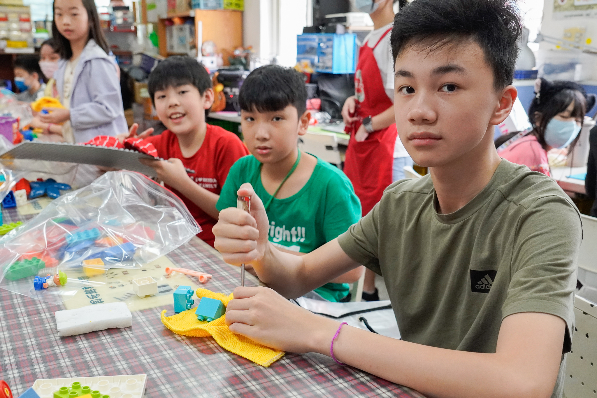 負責清潔玩具的張同學(右1)分享，很多玩具細小、難以清潔，眉角很多，光是擦玩具就很辛苦。陳同學(左1)則很期待這些玩具擁有下一個主人，且小朋友收到後會覺得開心。